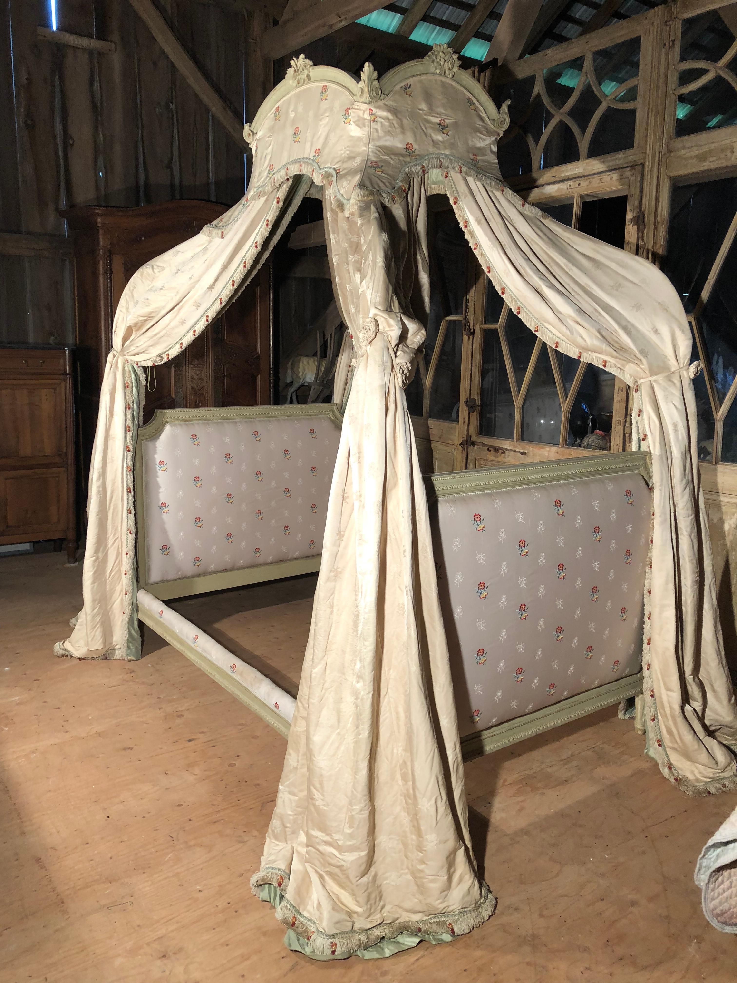 A “Lit a Polonaise” canopy bed with old silk draperies, late 19th century French, in the Louis XVI style, with a can bed and green painted beech frame, iron canopy supports.
The mattress size is an extra large full (54x 80). Mattress not