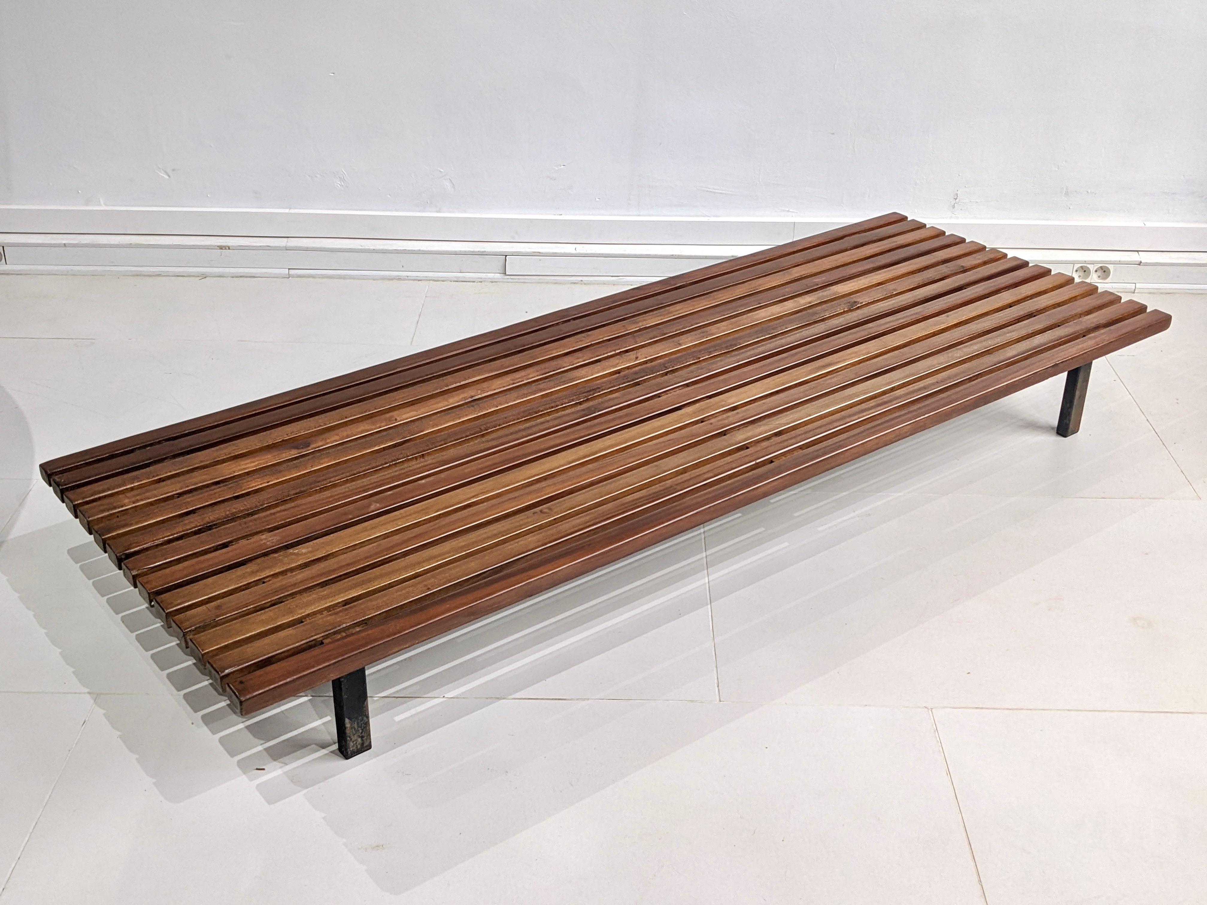Cansado bench sofa 13 slats by Charlotte Perriand.

Year 1954. In mahogany wood.
Steph Simon edition. Very good condition. 
Seat and back in grey fabric. They are not original. 
The bench has been varnished. Some small defects on the wood (see