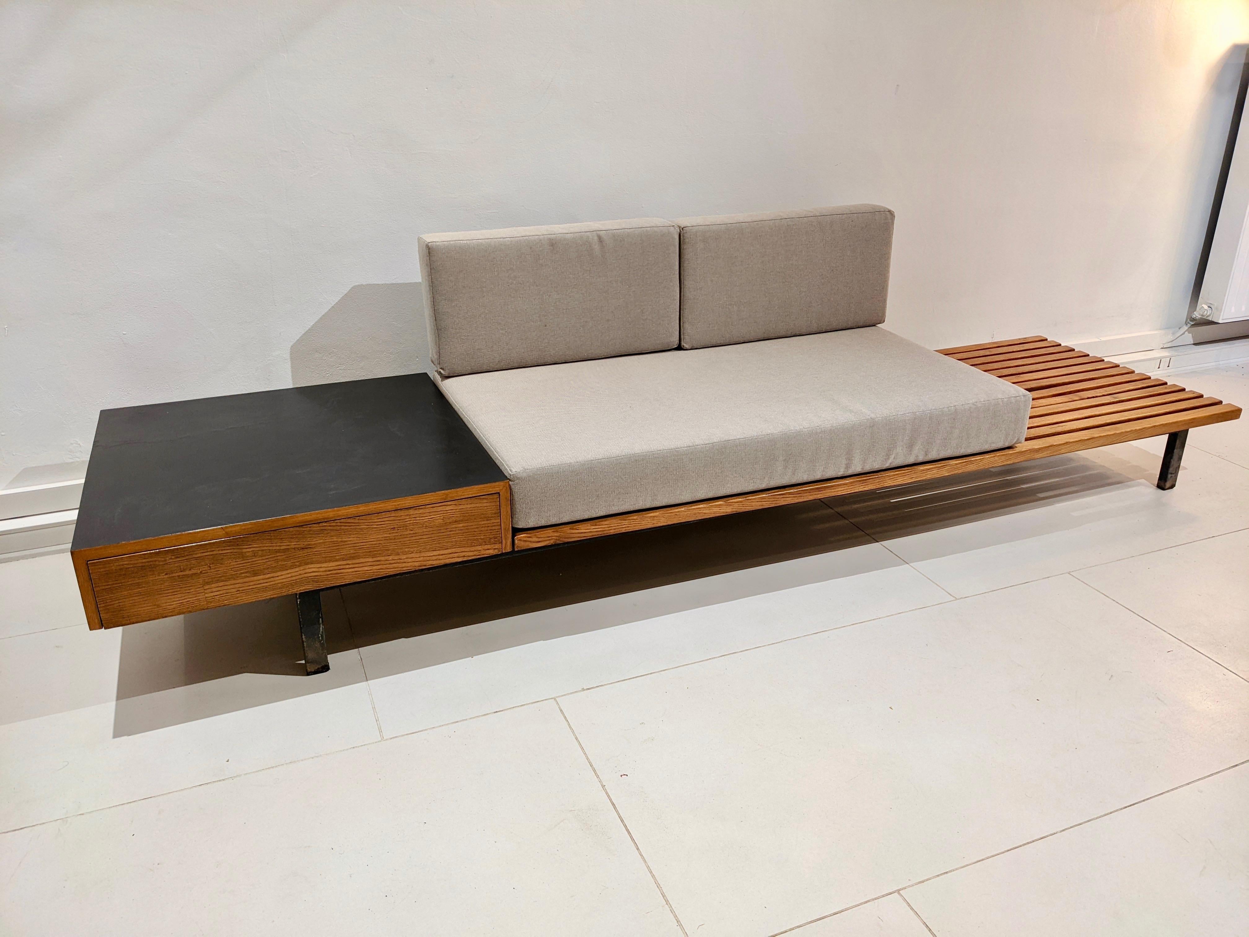 Cansado bench with drawer and cushion in grey fabric by Charlotte Perriand. Year 1954. Steph Simon edition. Good condition. 
Provenance : Cansado mining city, Mauritania, Africa.
Some defects are visible on the front of the drawer and on the