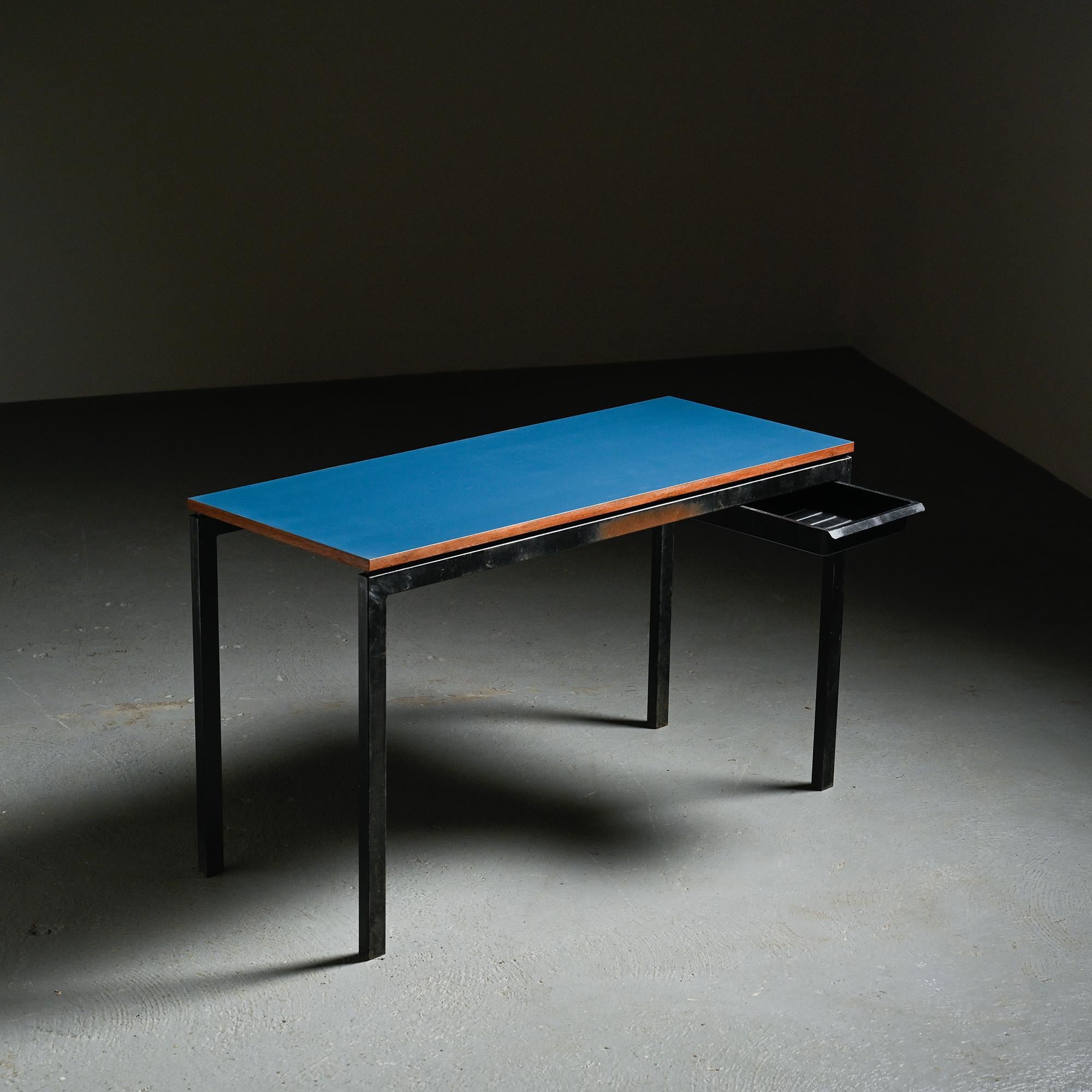 
Bureau conçu par Charlotte Perriand pour le village minier de Cansado entre 1959 et 1967. 

Elle présente un plateau stratifié bleu monté sur un cadre en métal tubulaire laqué noir, conçu pour être durable et facile à entretenir, conformément aux