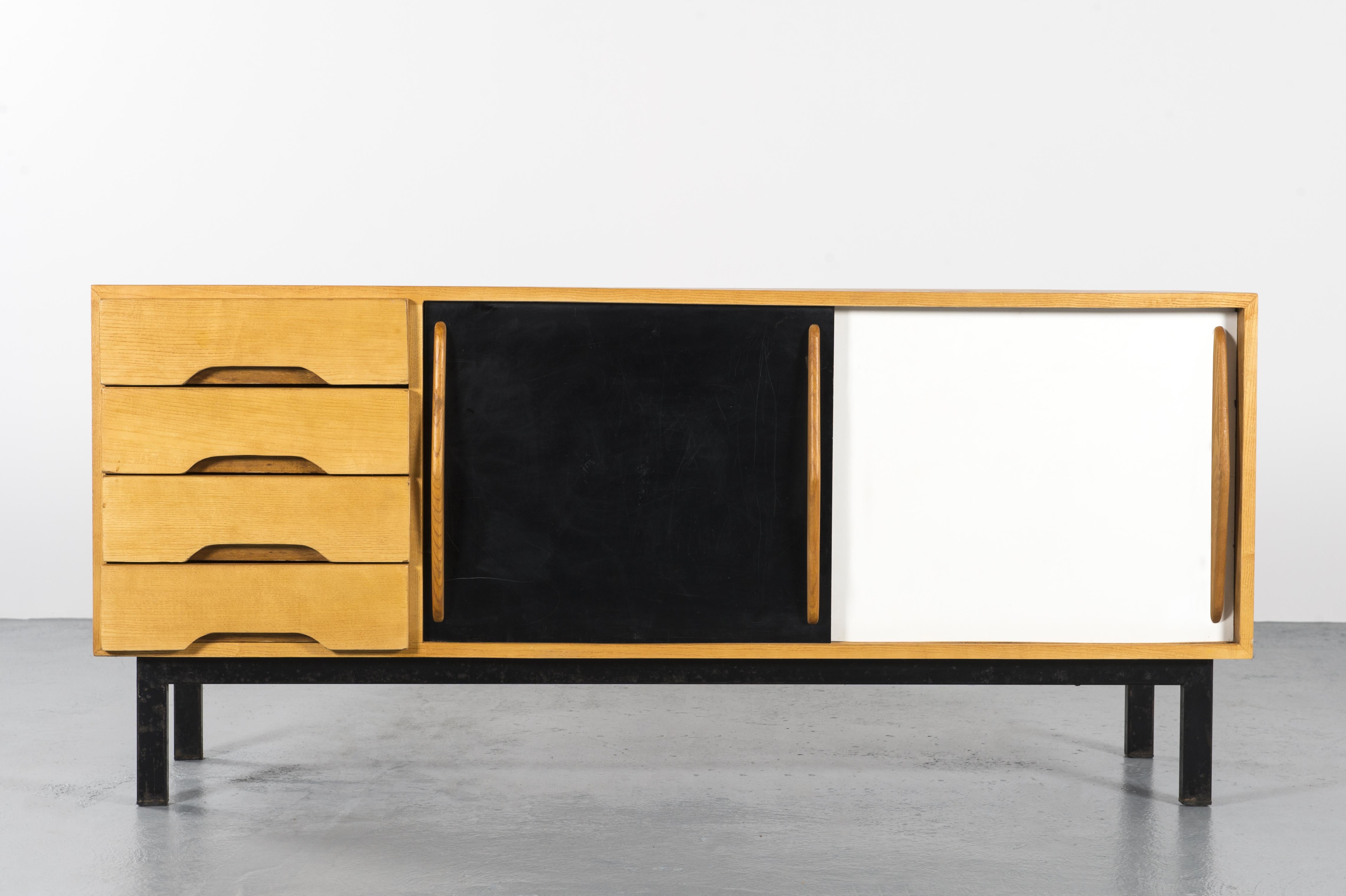 Cansado mining town Charlotte Perriand sideboard, circa 1960, Mauritania, North Africa

Sideboard in ash wood, two sliding doors in black and white laminated formica and four drawers on the side. The base is in painted black metal.

Charlotte