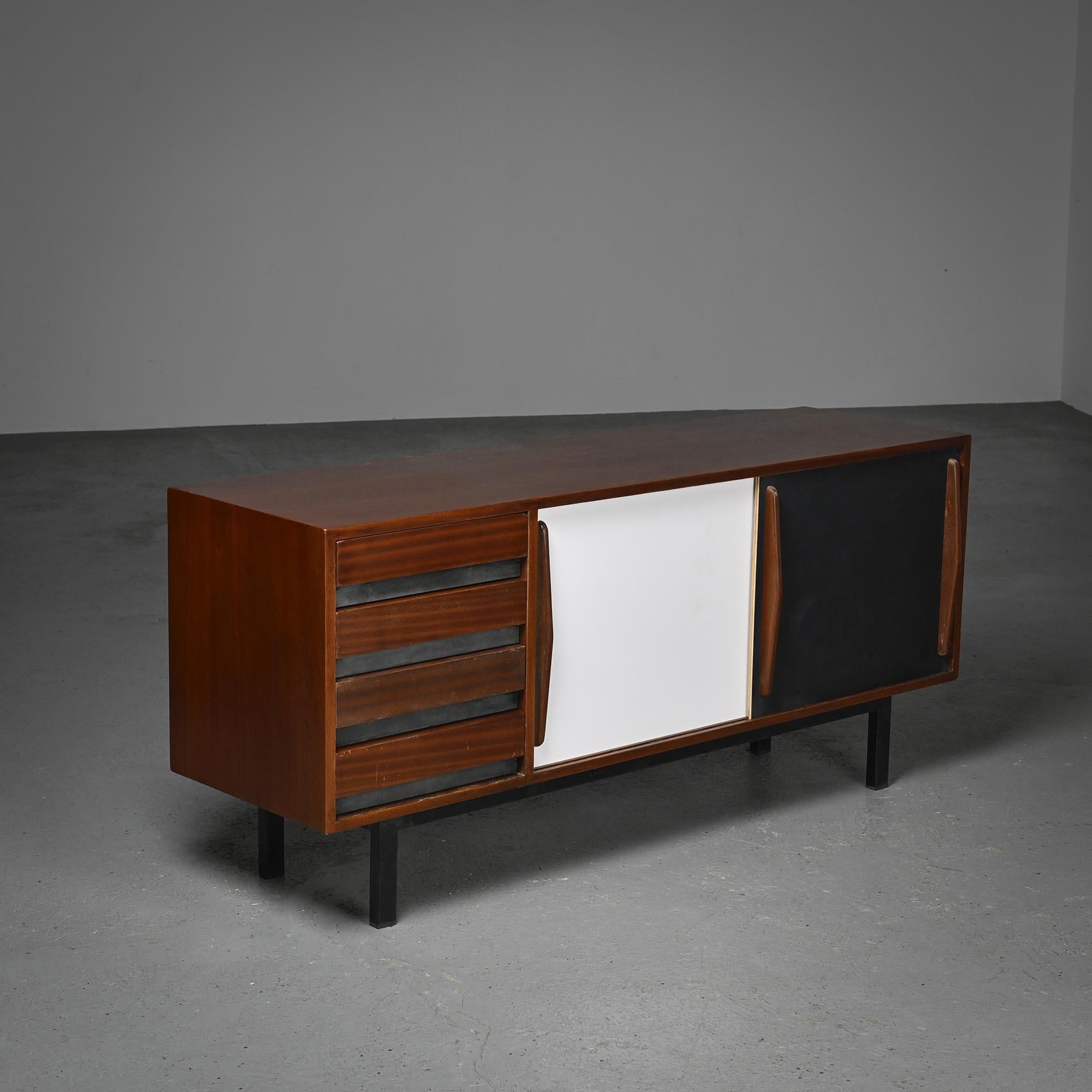  A sideboard by Charlotte Perriand, from the Cansado mining city in Mauritania. 

Structure in mahogany veneer, with two black and white laminate sliding doors, all resting on a black lacquered base. 

Manufacturer: Steph Simon, 1956-1974.