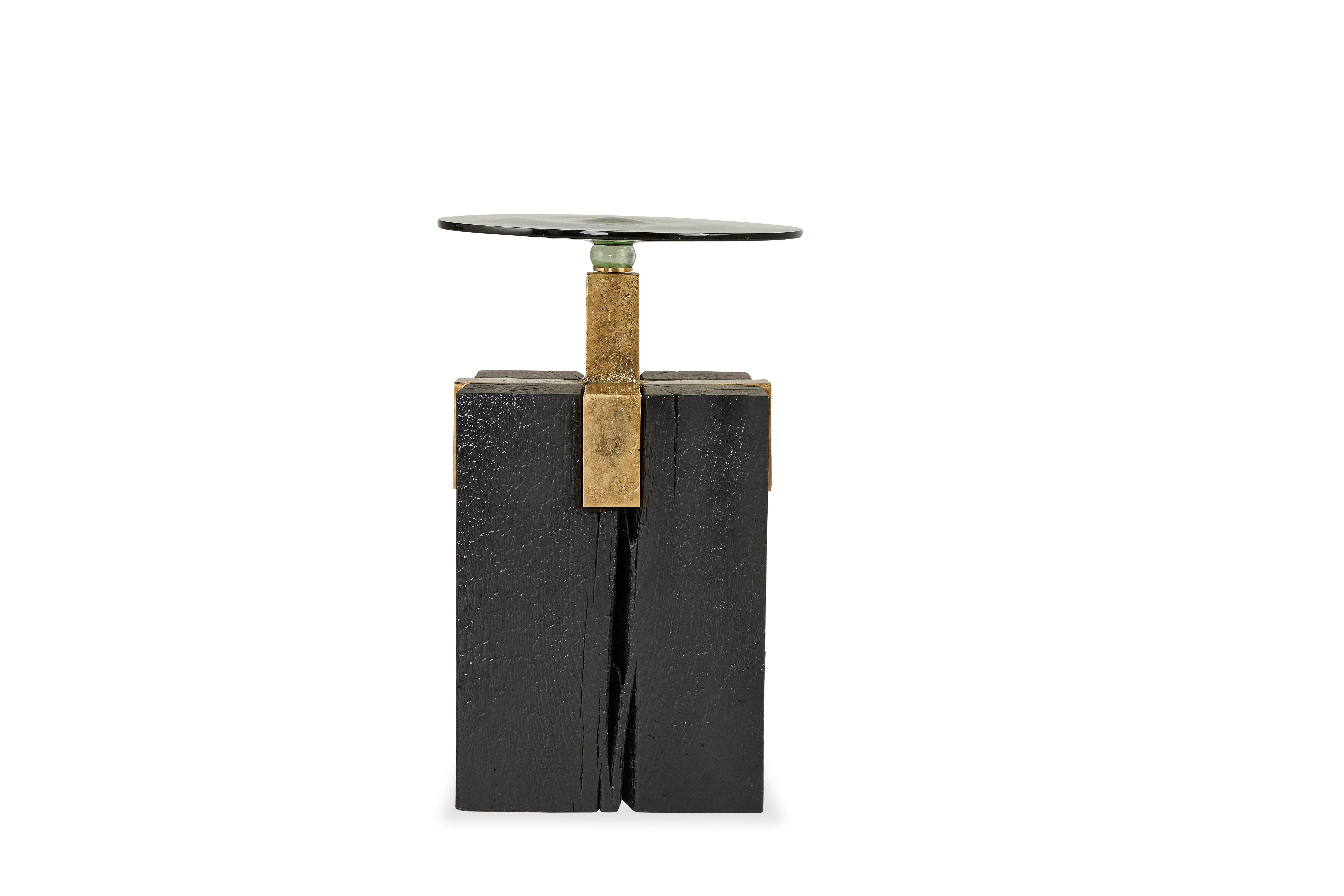 Table d'appoint Cant par Egg Designs
Dimensions : 40 L X 40 D X 62 H cm 
MATERIAL : Chêne massif, laiton, verre soufflé à la main

Fondé par Greg et Roche Dry, deux Sud-Africains et partenaires dans la vie, Egg offre une perspective unique en