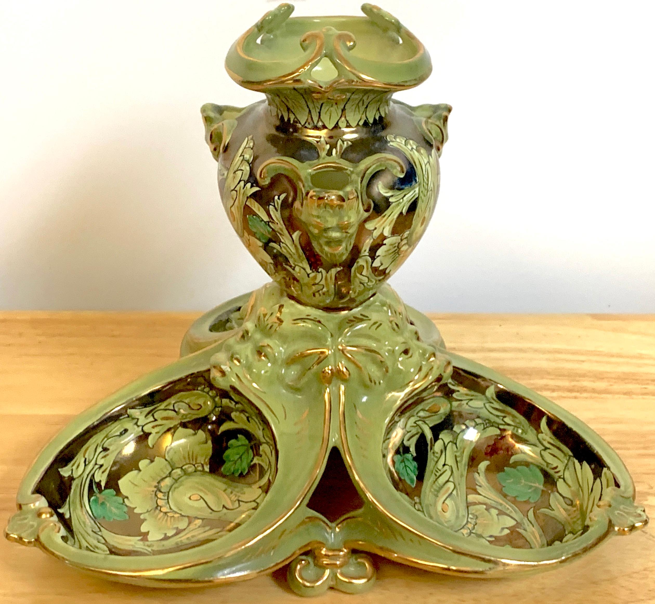 Cantagalli Lusture Majolica centerpiece, Of tripartite form with center pierced urn, with mask medallions, raised on a confirming ovoid base. Decorated in all over foliate and scroll lusture decoration.