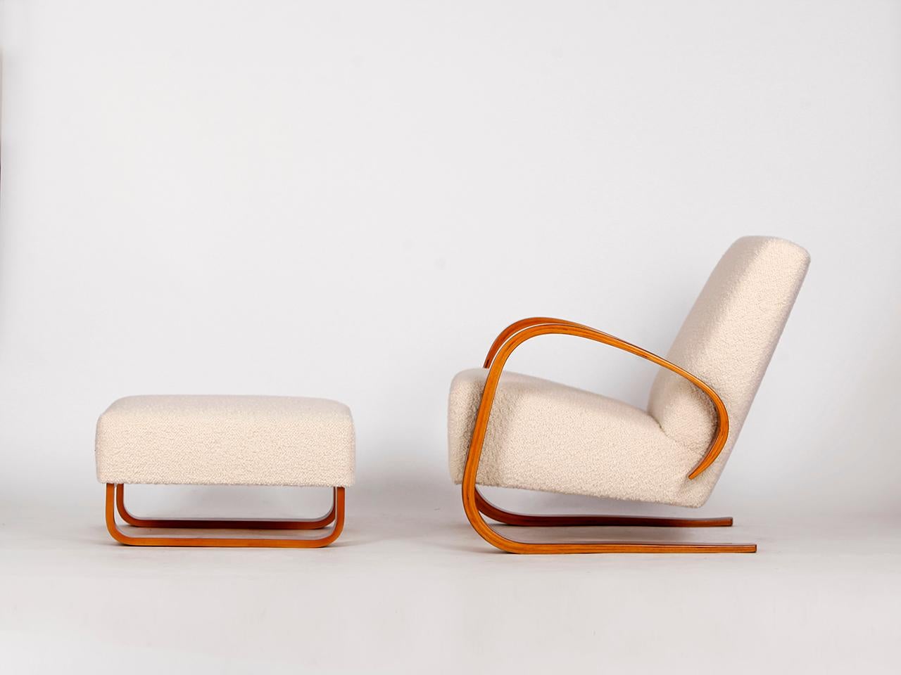 Designed by Miroslav Navratil for Spojene UP Zavody in the 1950s. Completely restored with lacquered walnut veneered armrests and a new spring core. With a wonderfully soft english cover boucle fabric made of wool. If desired, the matching stool can