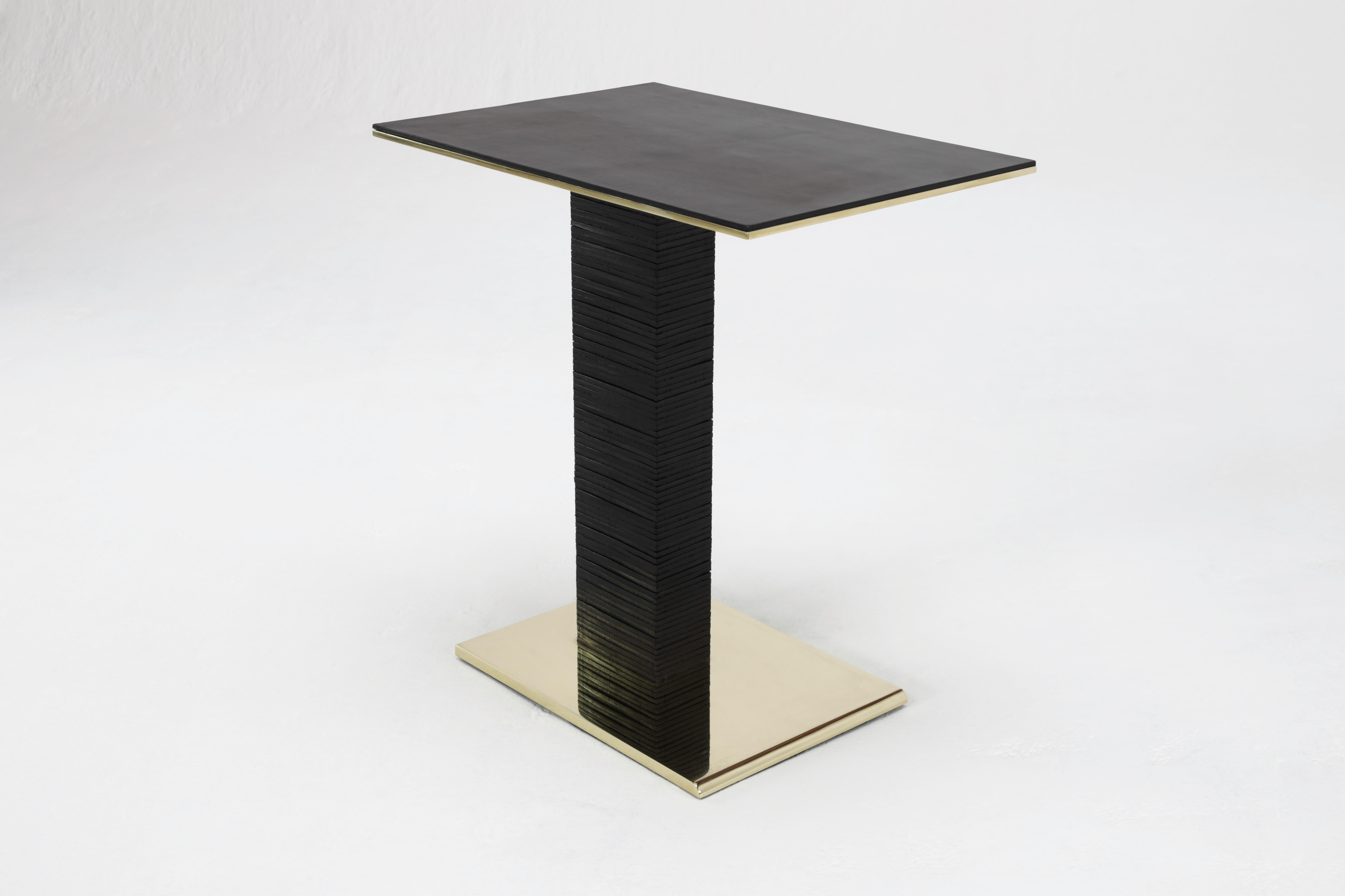 The Cantilever Infinity side table was inspired by Paul Dupré-Lafon's use of stacked leather in his designs for Hermès. The base is solid brass, beveled at the front, and mirror polished on all sides. Over eighty pieces of leather are stacked to
