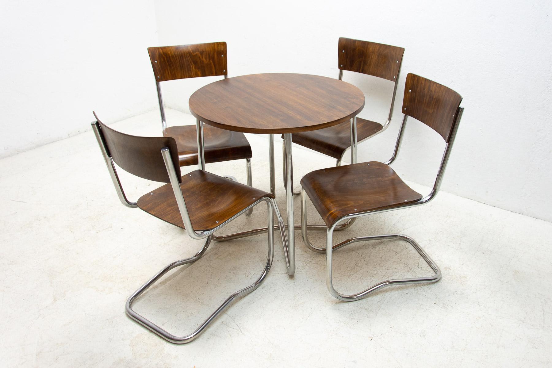 A cantilever lounge furniture set made in the 1930s and consisting of one coffee table and four dining chairs by Hynek Gottwald. Fully expertly renovated, the original wooden parts was cleaned and rubbed, high gloss polyurethane lacquer in original