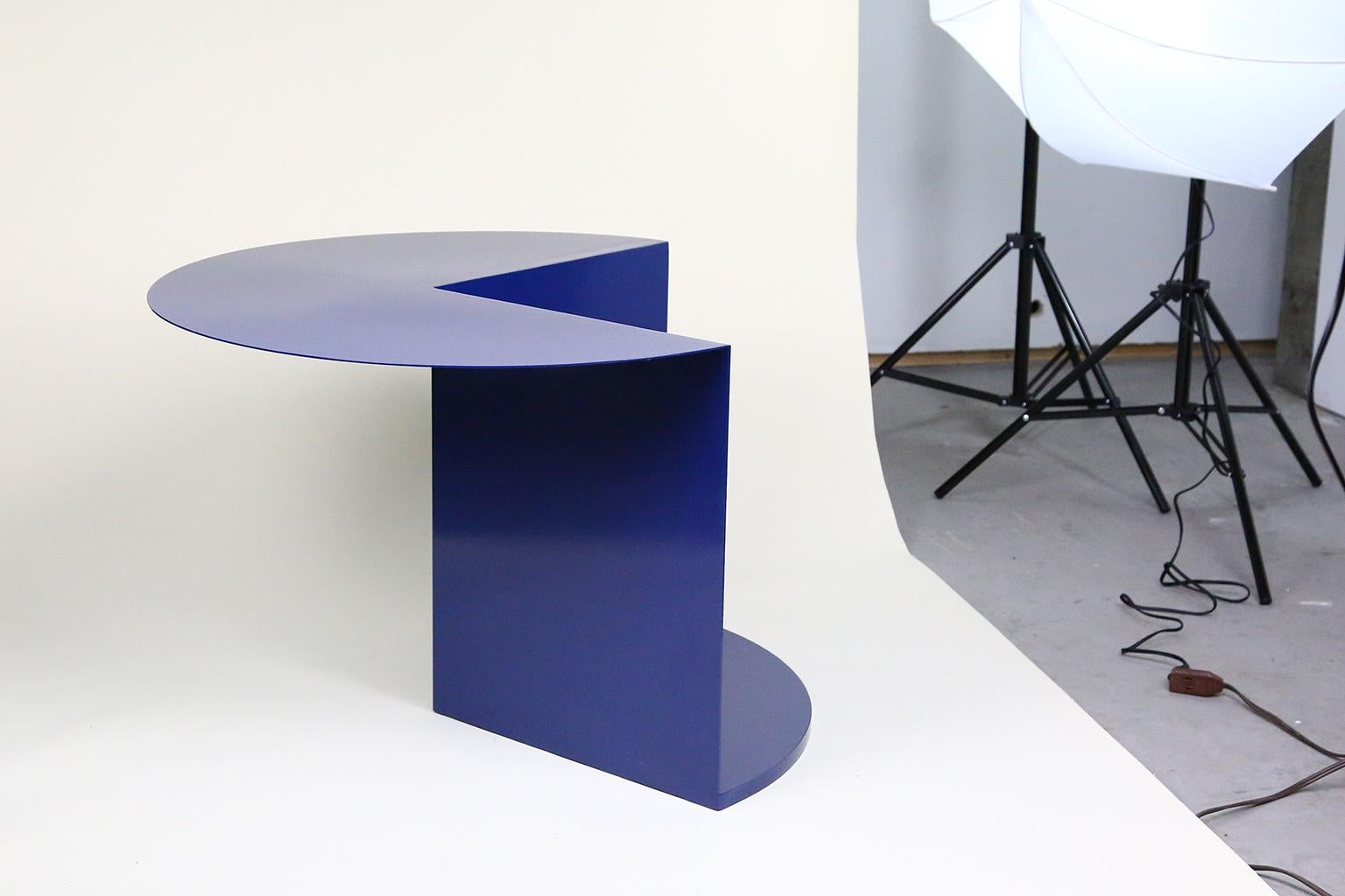 The coffee/side table consists of only necessary parts. The top panel functions as the surface of the table. The two vertical panels and the bottom surface create support for the table and suggest a space for the storage or display of personal