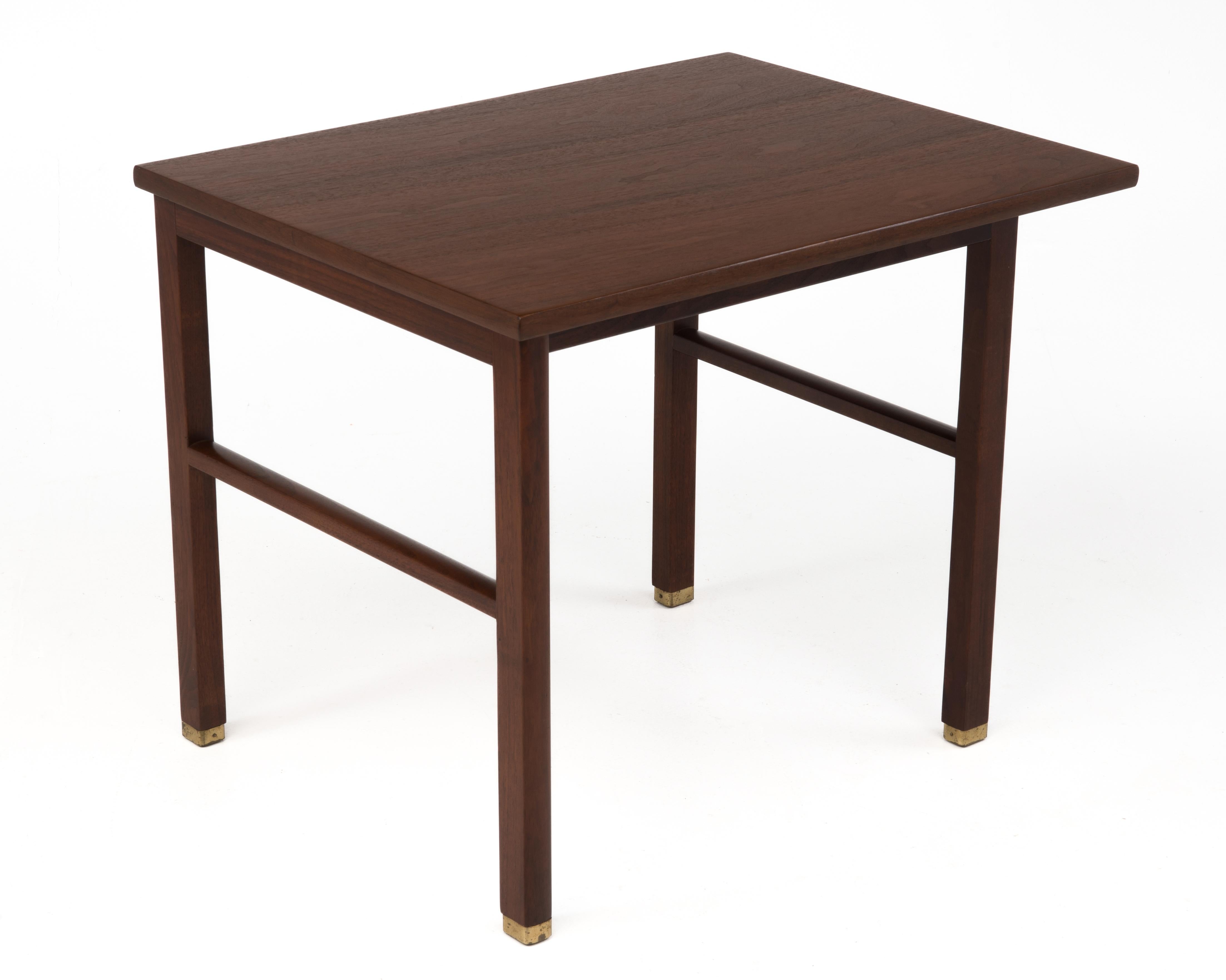 A Mid-Century end or side table by Edward Wormley for Dunbar, c. 1960's. The table features a cantilevered top and brass feet. It retains the original Dunbar brass tag.