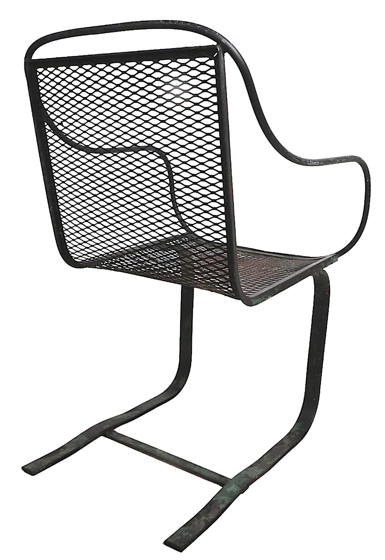 Chic architectural cantilevered mid century lounge arm chair, attributed to Salterini. The chair has a wrought iron frame, cantilevered spring base, and continuous metal mesh seat and back. 
Total H 33.5 x Arm H 25.5 x Seat H 16 x W 21 x D 21.5