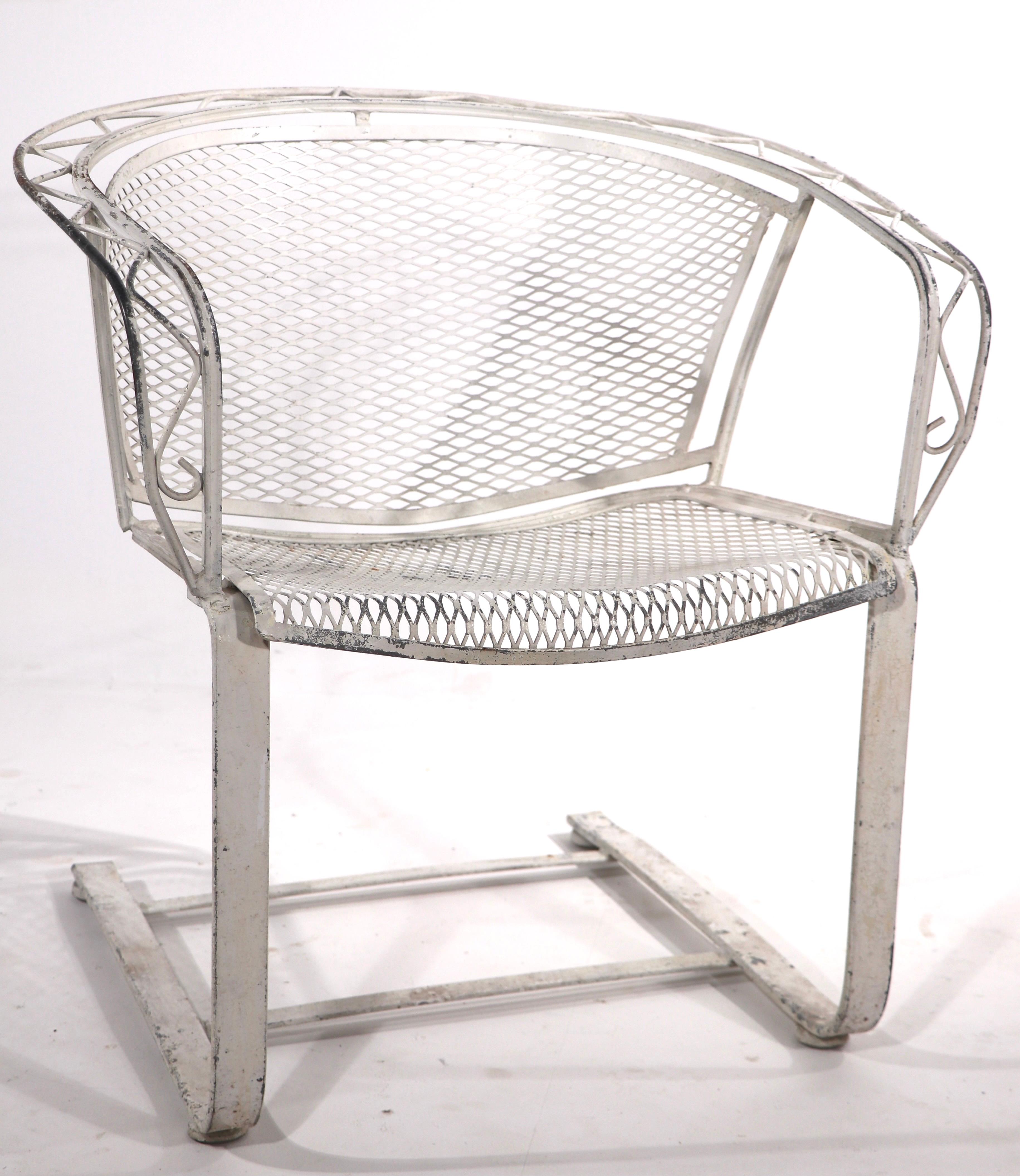 Hard to find cantilevered lounge chair by Salterini. This example has a wrought iron frame with zig zag metalwork trim, and metal mesh seat and back. The chair is in very good original condition, no breaks, bends damage or repairs. The paint finish