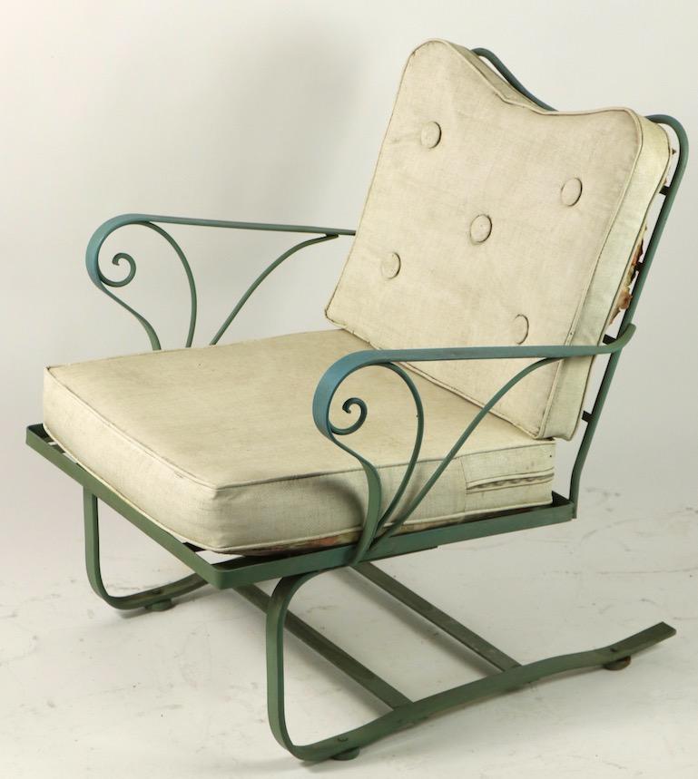 Chic and stylish wrought iron cantilevered lounge chair by Woodard. This example is in good original condition, however the cushions are extremely worn and will have to be replaced. The paint finish (original) shows minor cosmetic wear, normal and