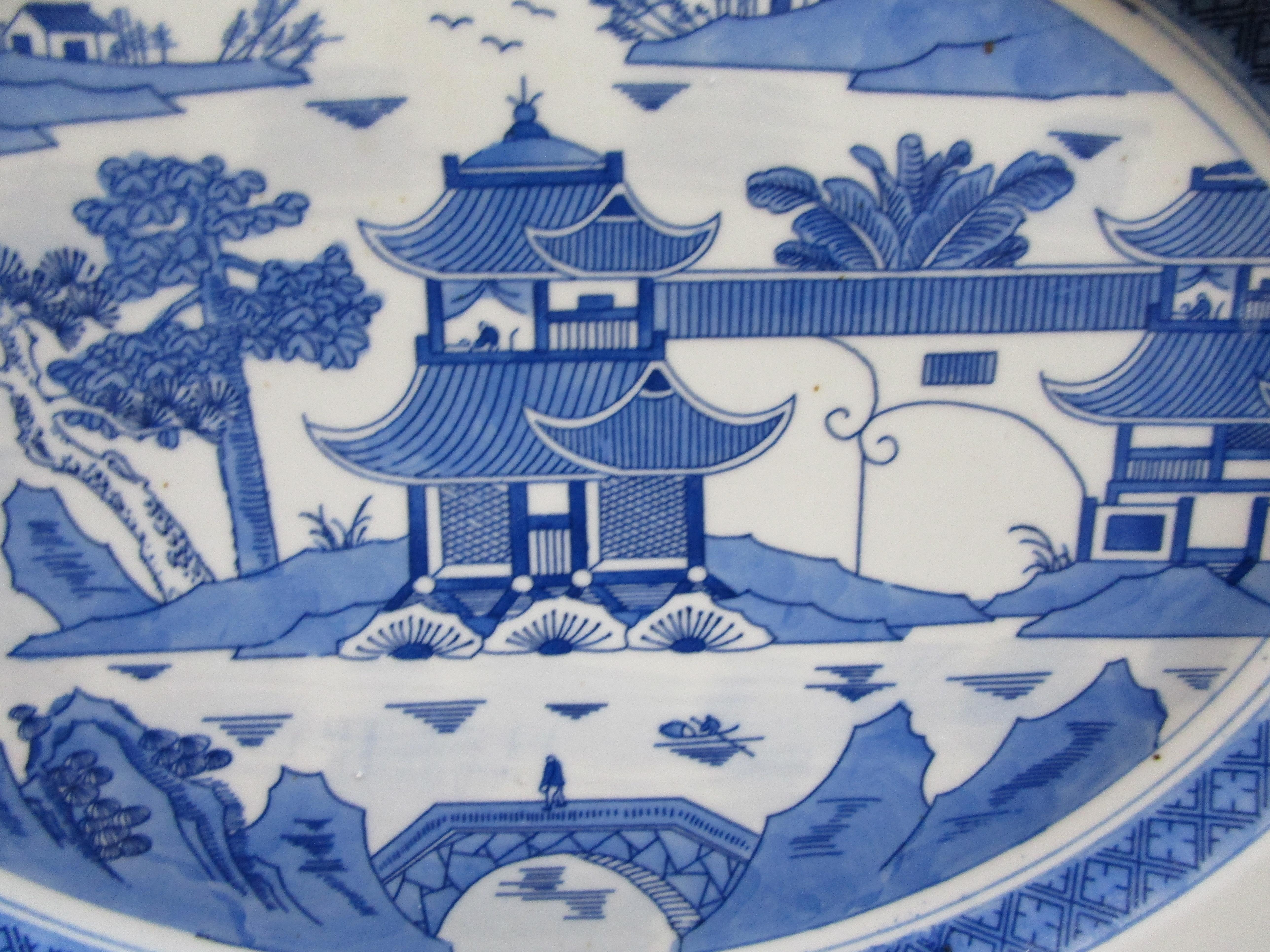 This platter is a wonderful oval platter, Canton ware in blue and white with a backstamp on the reverse side that says Made in China. This is a mid-century piece of export China. The border on the inner rim is called rain and cloud, which seems to