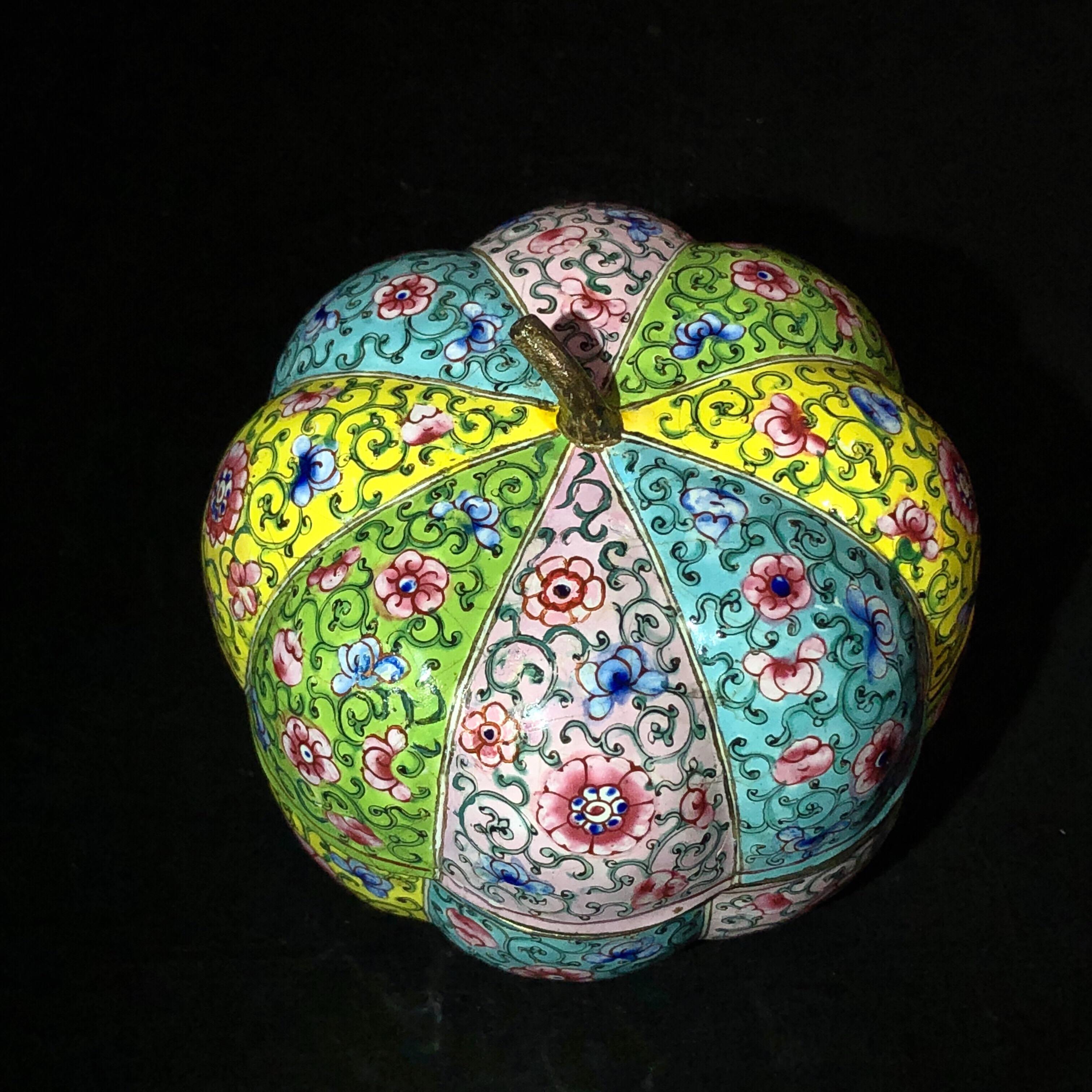 Chinese Cantonese enamel pumpkin form box, the eight-lobed form each painted in bright scrolling foliage on alternating yellow, green, blue and pink grounds, the interior pink.
Qianlong,
circa 1780.
  