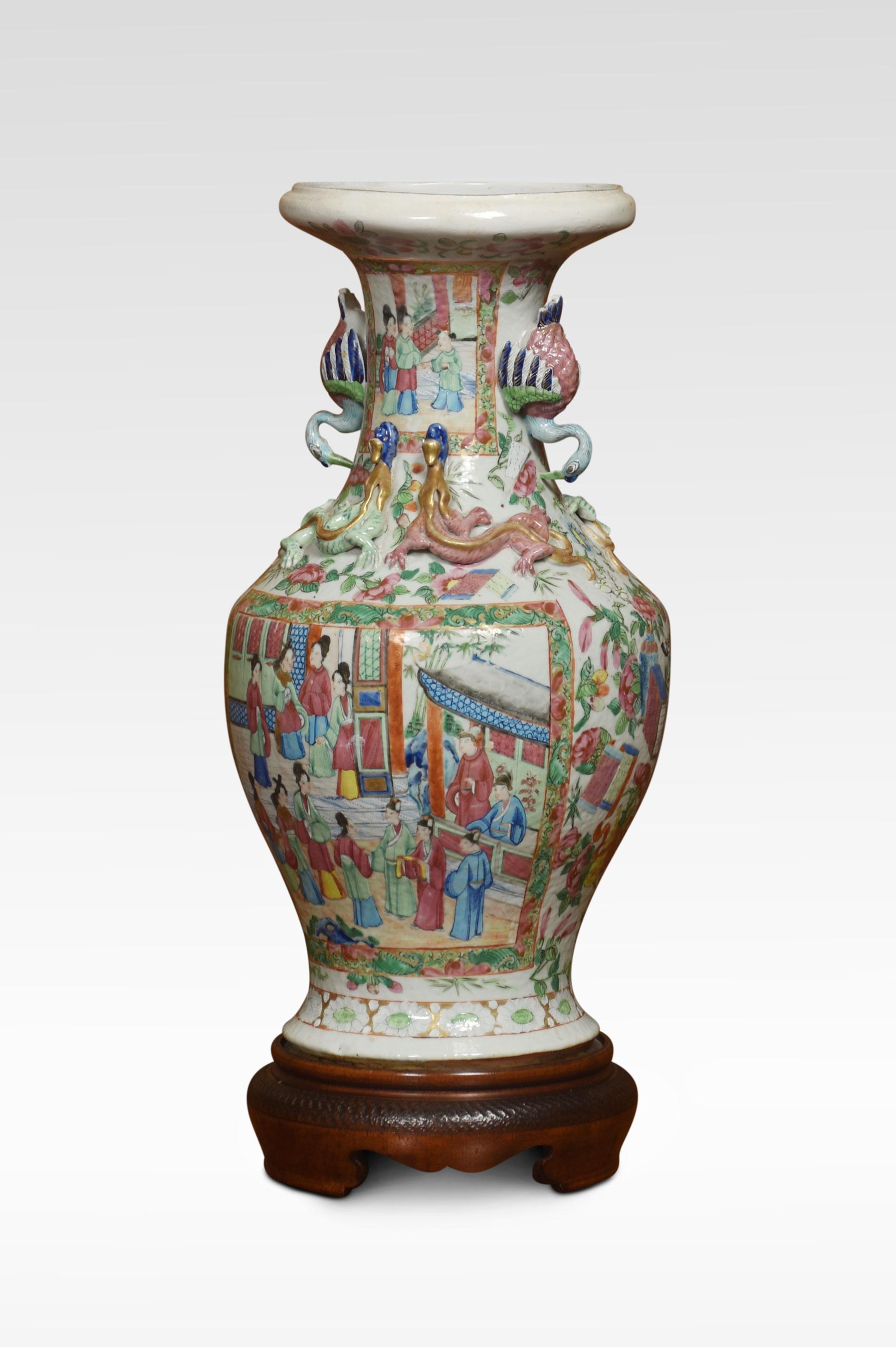 Cantonese twin-handled baluster vases, decorated in the famille rose palette with cartouche panels of figures, exotic birds and insects amongst the foliage. Raised up on a circular wooden base.
Dimensions
Height 19 Inches
Width 9 Inches
Depth 9