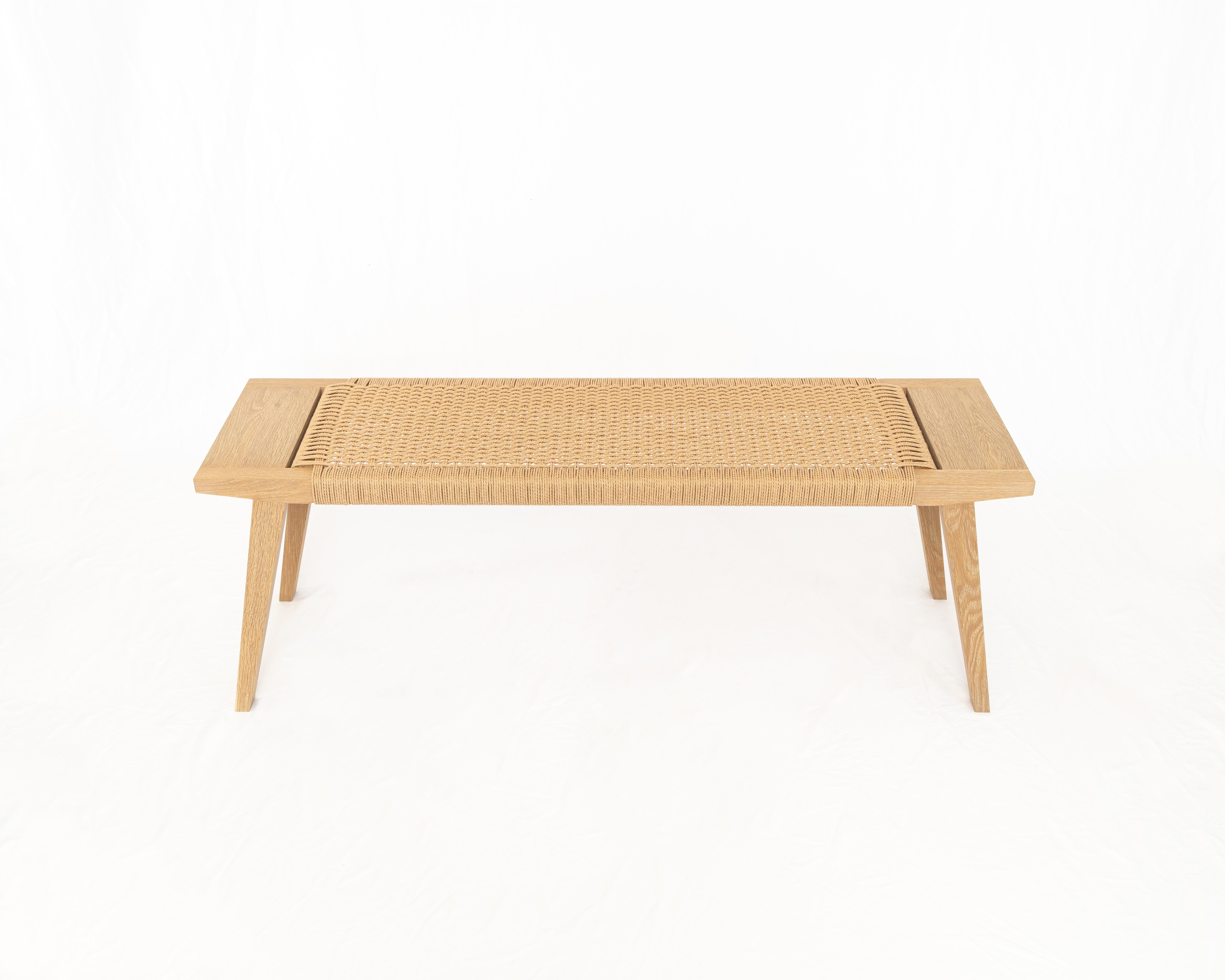 Avec son cordon de papier tissé, son bois d'œuvre durable et ses cônes modestes, le banc Canva explore l'amour des matériaux et de l'artisanat soudé à un accueil chaleureux. Construit avec une structure à tenon et mortaise et un siège tissé à la