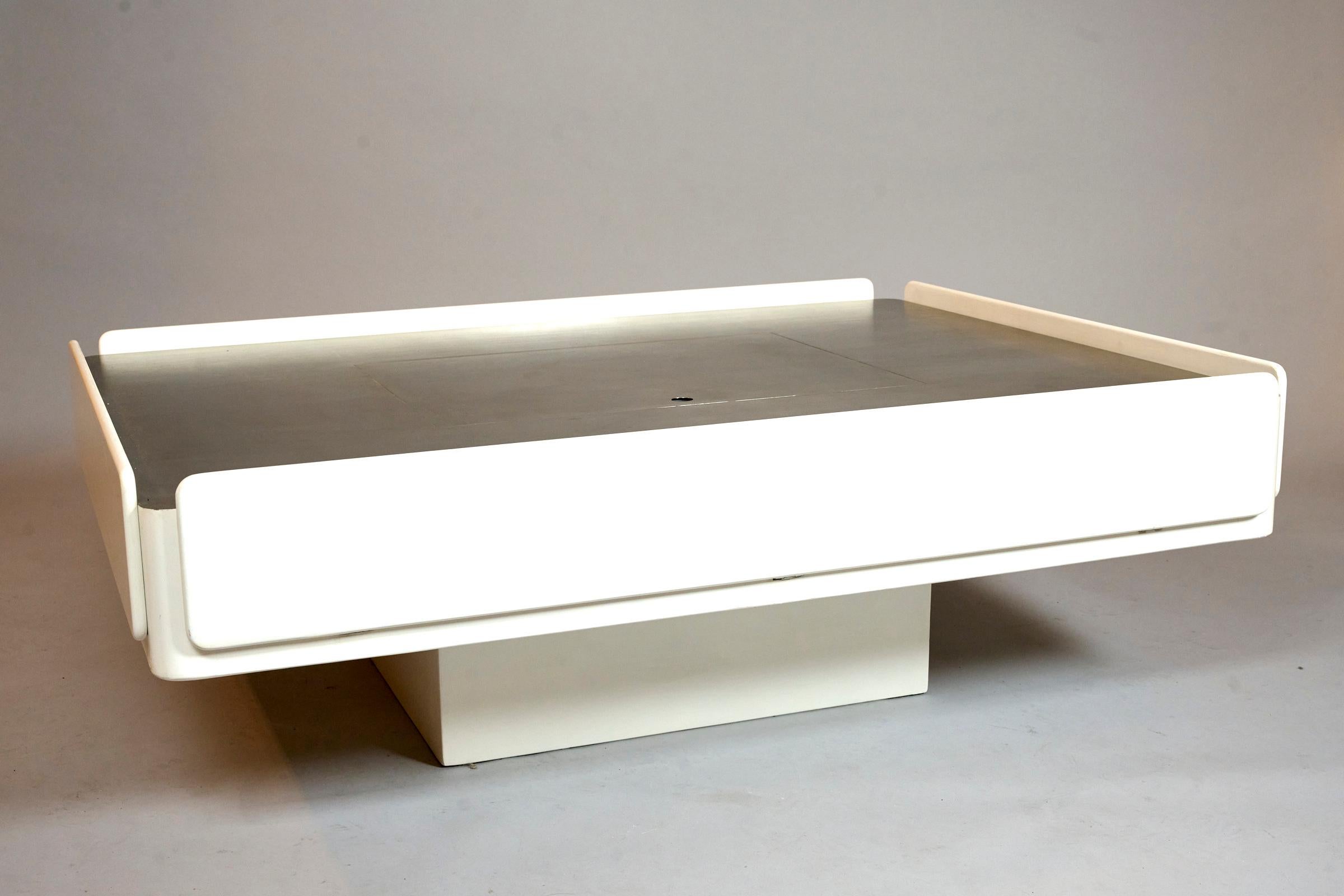 Iconic 'Caori' coffee table with storage. Italy c1962

Matt white lacquer and stainless steel

Ingenious coffee table with concealed storage

Contains two pull out drawers. Two flip down compartments on either side, and a lift up compartment