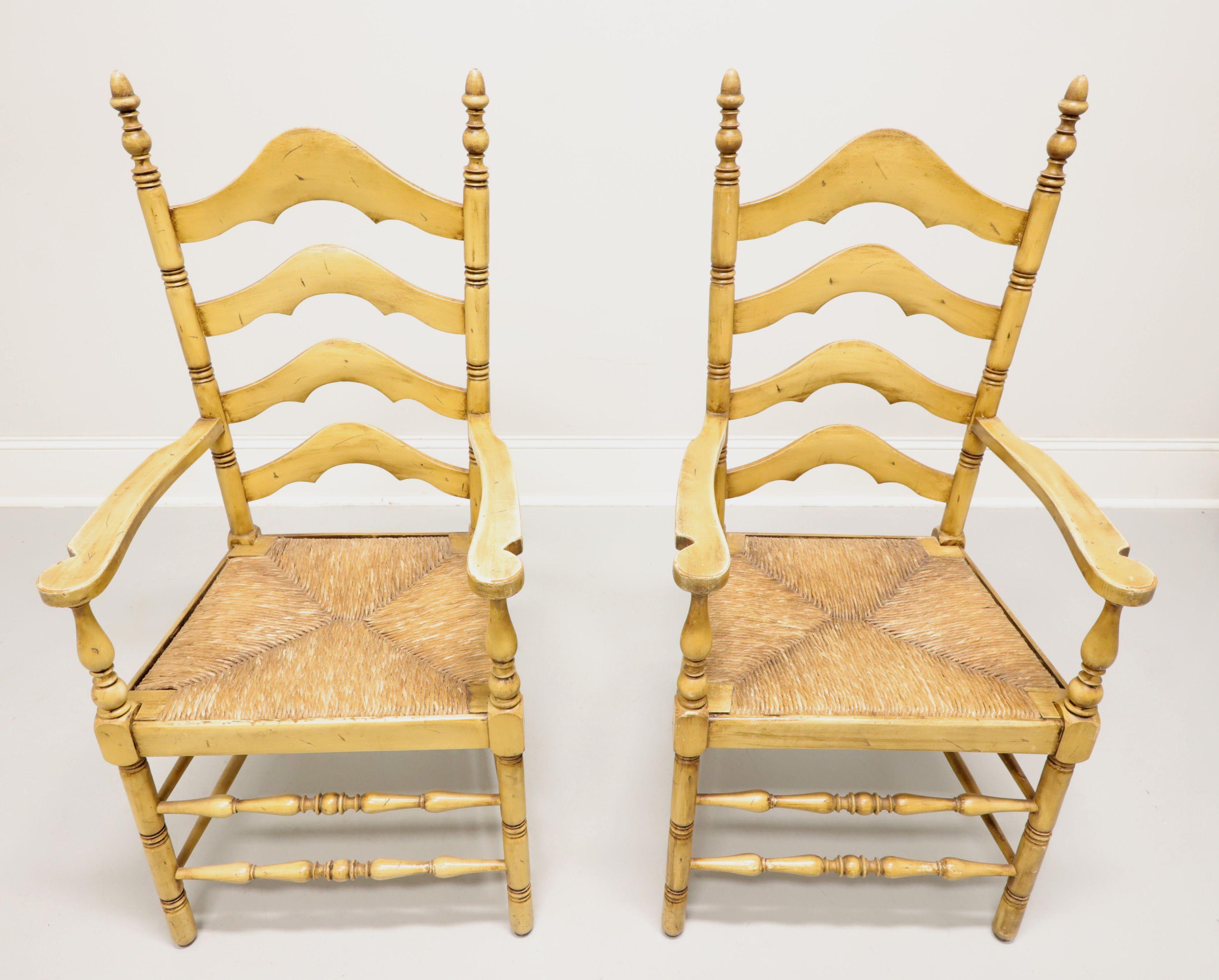 A pair of Cottage / Farmhouse style dining armchairs by Cape Ann Chairs. Maple with carved arched ladder back design, finial capped stiles, slightly curved arms with turned supports, rush seats, turned front legs & front stretchers, and solid back