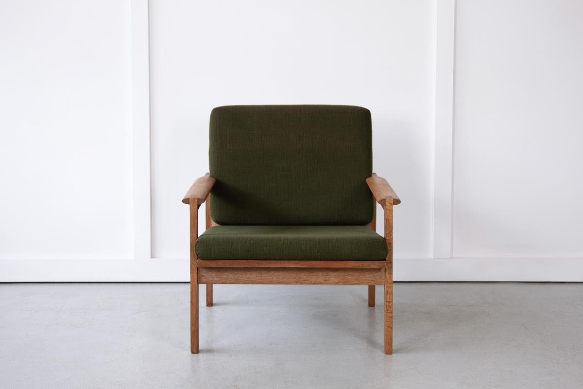 The handsome 'Capella' armchair by Illum Wikkelsø for Niels Eilersen featuring a lovely oak frame with relaxed stance and slatted back. The box cushions are currently in their original green upholstery which has been cleaned.
