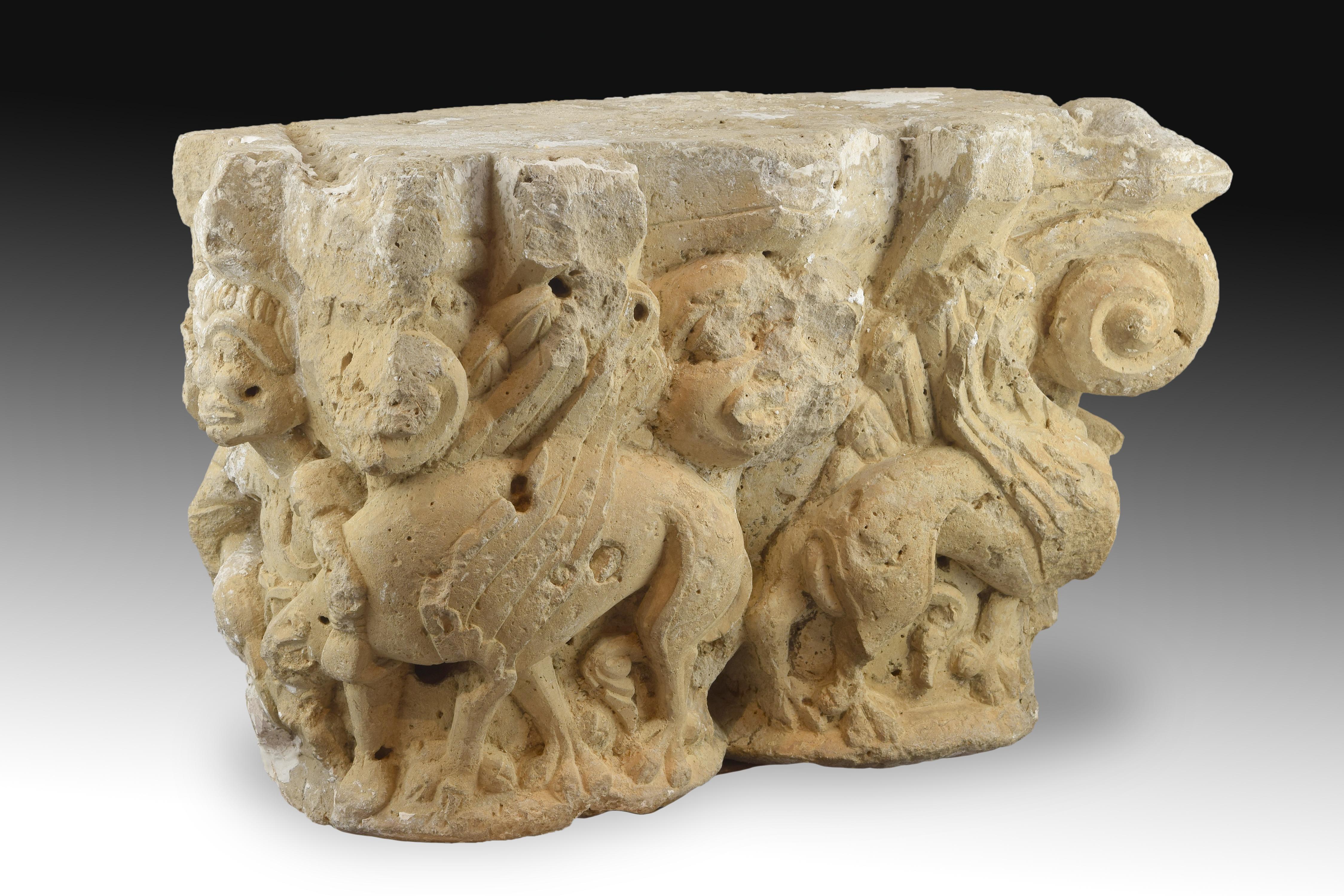 Double capital made of carved limestone decorated with volutes in relief in the corners and figurative elements in front and sides of the piece; presents size on both sides, with the same theme. In the center there is a mask with humanoid features,