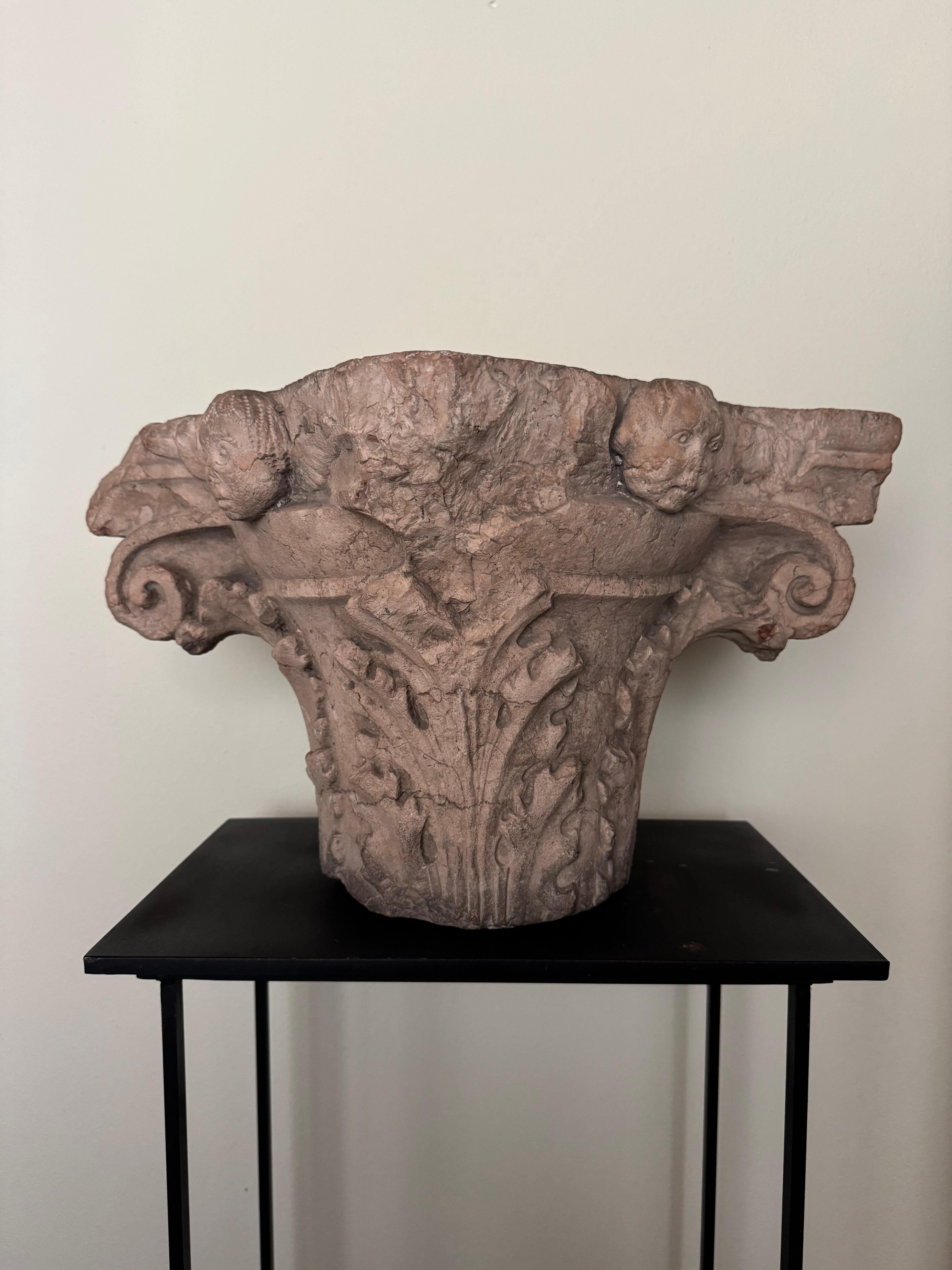 Capitello corinzio a foglie d'acanto della fine del XV secolo, in marmo rosso di Verona. I quattro angoli superiori del capitello vedono scolpite delle testine di angeli, una variante che si trova nelle reinterpretazioni dello stile corinzio anche