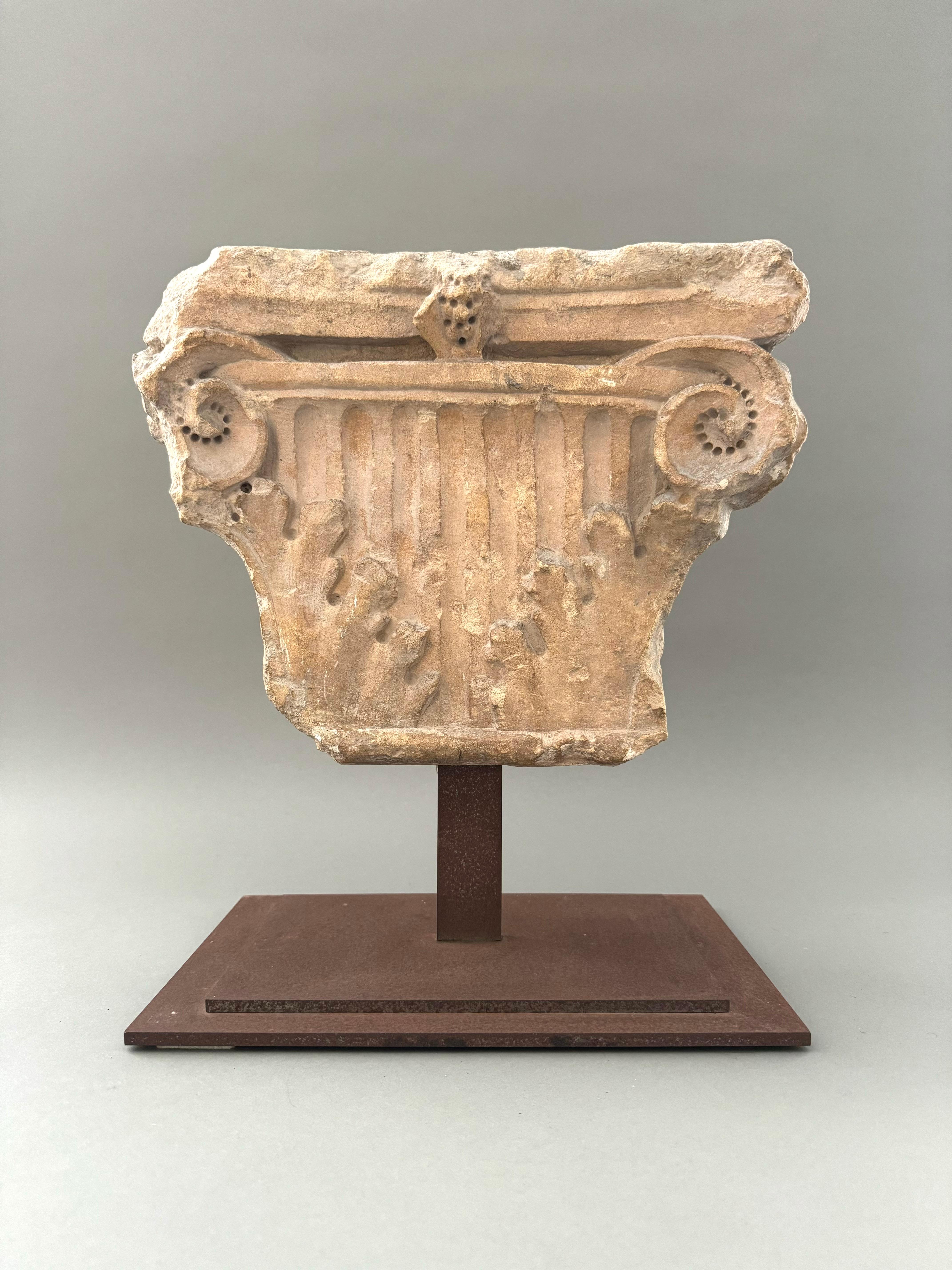 Capitello corinzio a colonna piatta in marmo della prima metà del XVI secolo. Presenta il tipico ornamento con foglie di acanto, pianta naturalmente attratta dalla luce del sole e spesso utilizzata nell'architettura cristiana come simbolo di