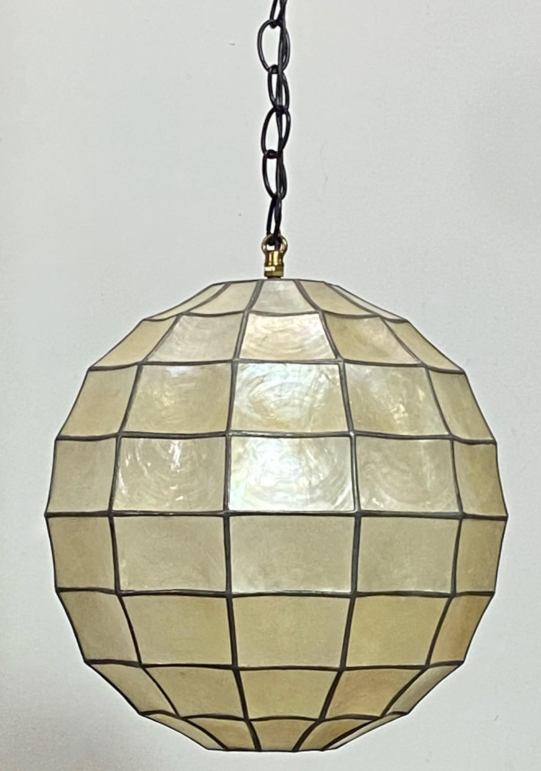Mid-Century Modern round shape Capiz shell hanging pendant light fixture.
Recently cleaned and re-wired. Shown in photos with a 60 watt LED light bulb.
In excellent vintage condition and ready to install.
We can shorten the chain to buyers