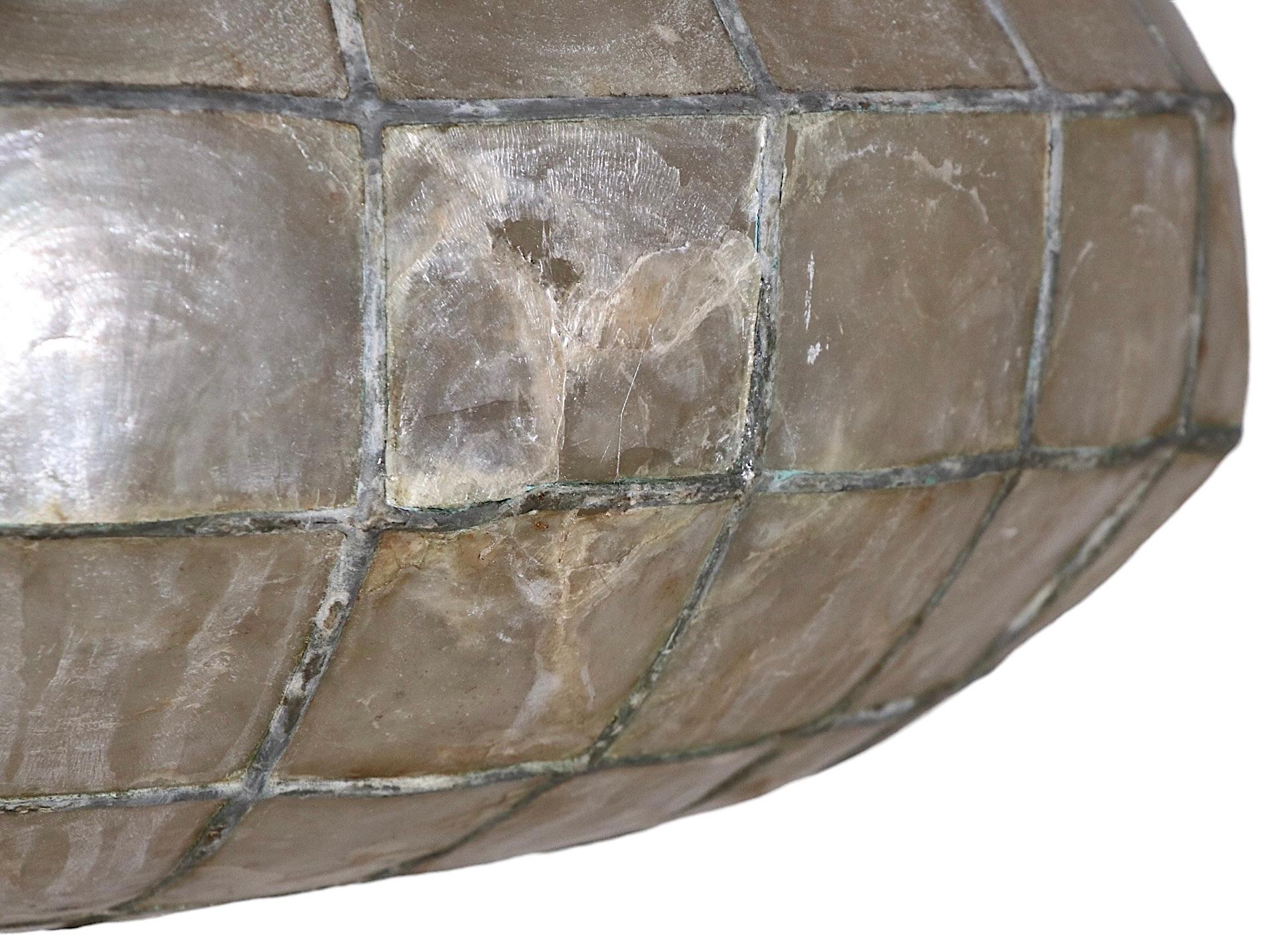 Decorative pendant hanging fixture constructed of capiz shell rectangular panels, with a leaded frame work structure. The chandelier is in good condition, it does show some flawed panels, they show an old glue repair, they are structurally sound,
