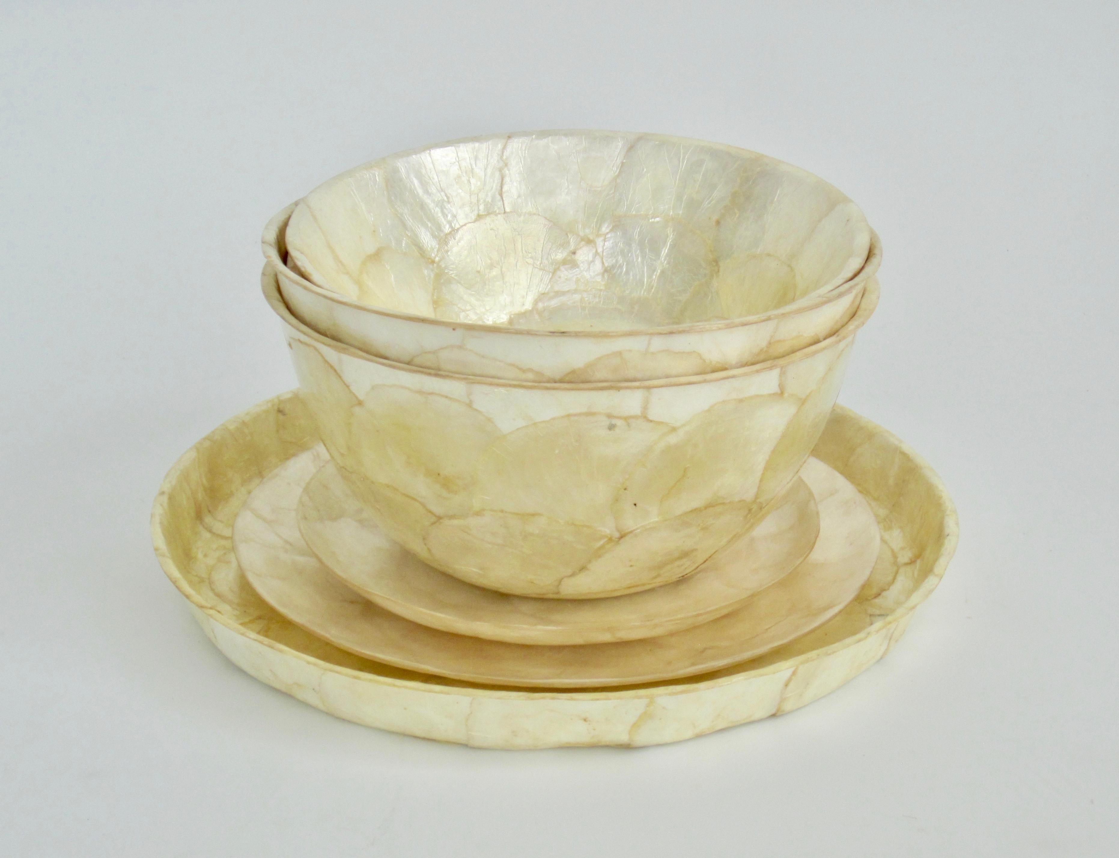 Seven piece set includes four bowls, two plates, and one round platter.
Handmade in the 1970s, each piece has been formed with capiz shell, a thin almost translucent shell found in the Indo-Pacific. It is also known as the windowpane oyster and has