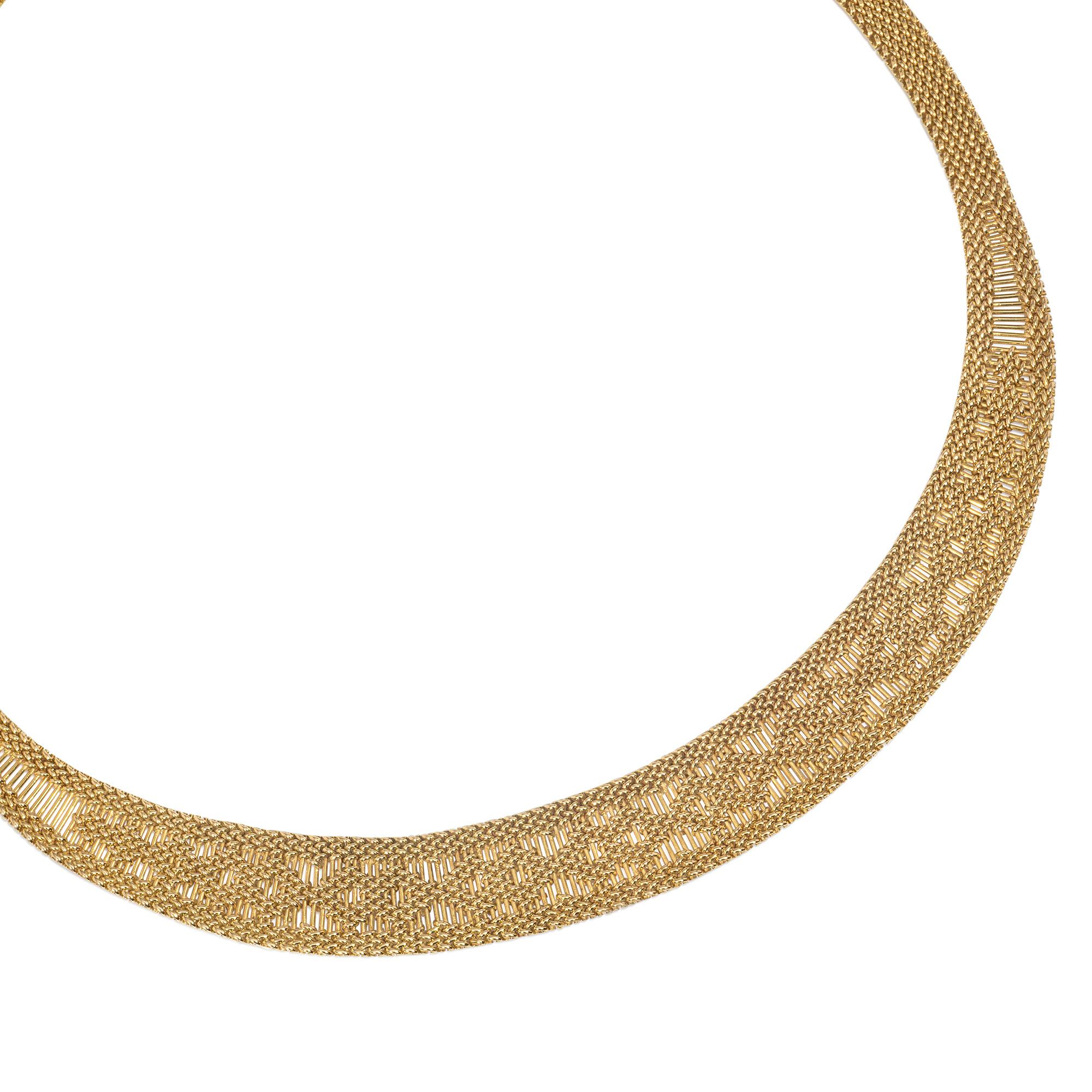 An estate 1970s gold collar necklace of woven and tapered design, the central openwork section featuring graduated vertical gold wires overlaid with interlocking diamond motifs, in 18k.  Caplain, Paris.

Dimensions: Approximately 43.2cm long, width