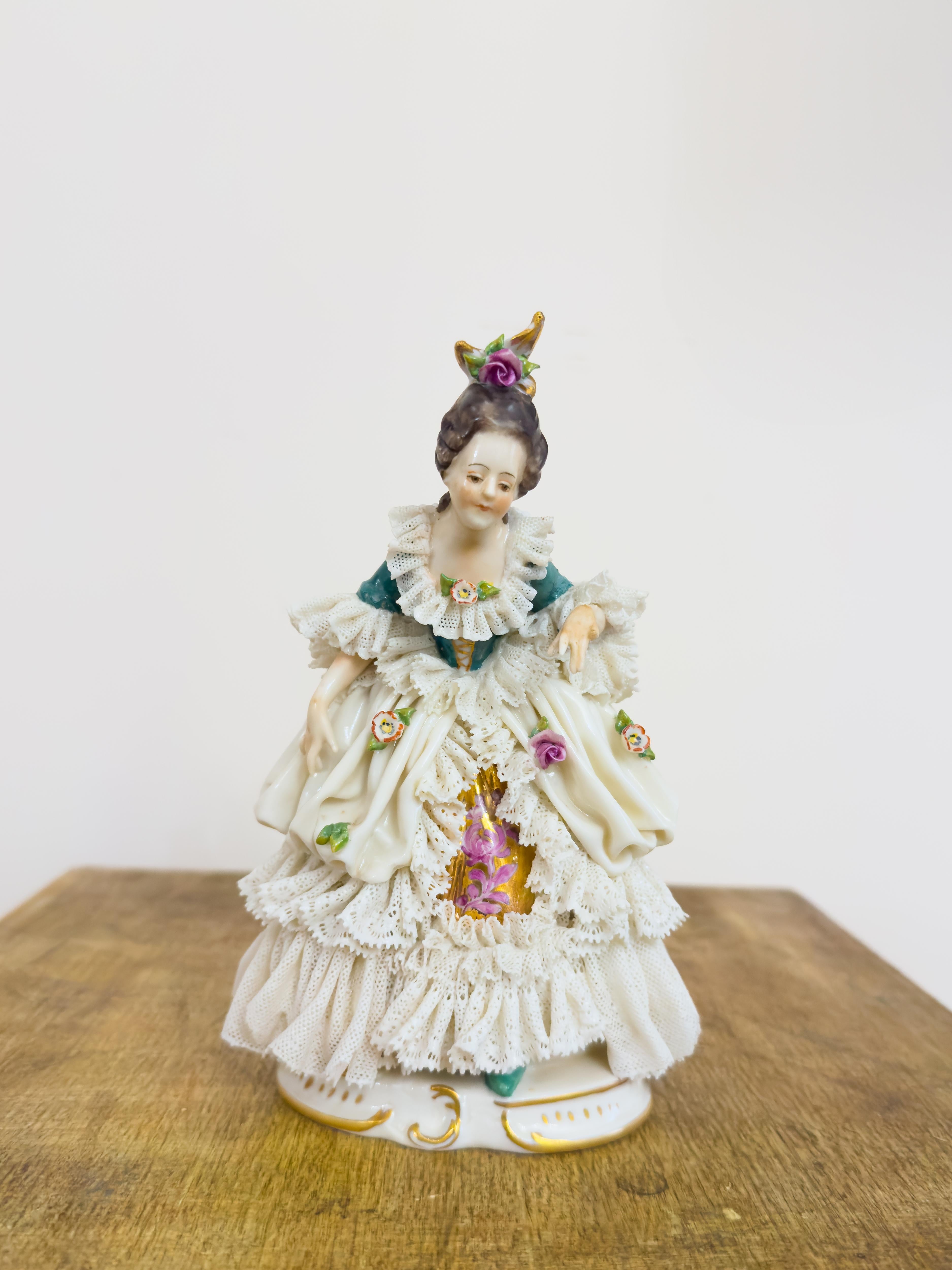 An exquisite early 20th-century Capodimonte porcelain figurine depicting a Baroque lady dressed in layered lace with floral embellishments.

Handcrafted in Italy around 1900, this translucent soft-paste porcelain sculpture is a beautiful example of