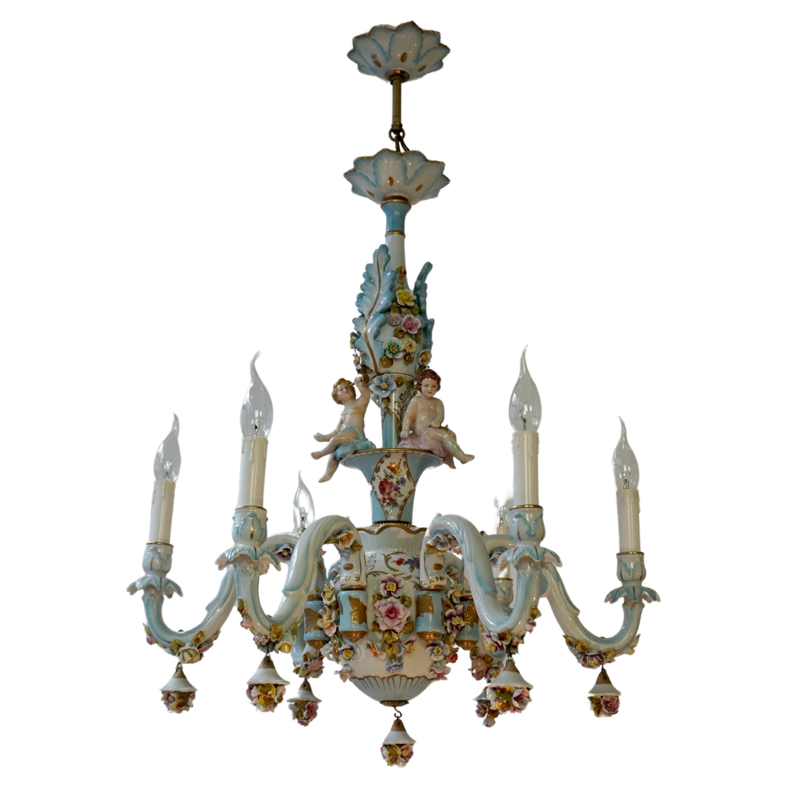 Magnificent Capodimonte chandelier with six lights and three hand painted Cherubs + seven hanging roses.
This one-tier porcelain chandelier has an exceptional quality. It is crafted and hand painted by the renowned Italian Capodimonte pottery