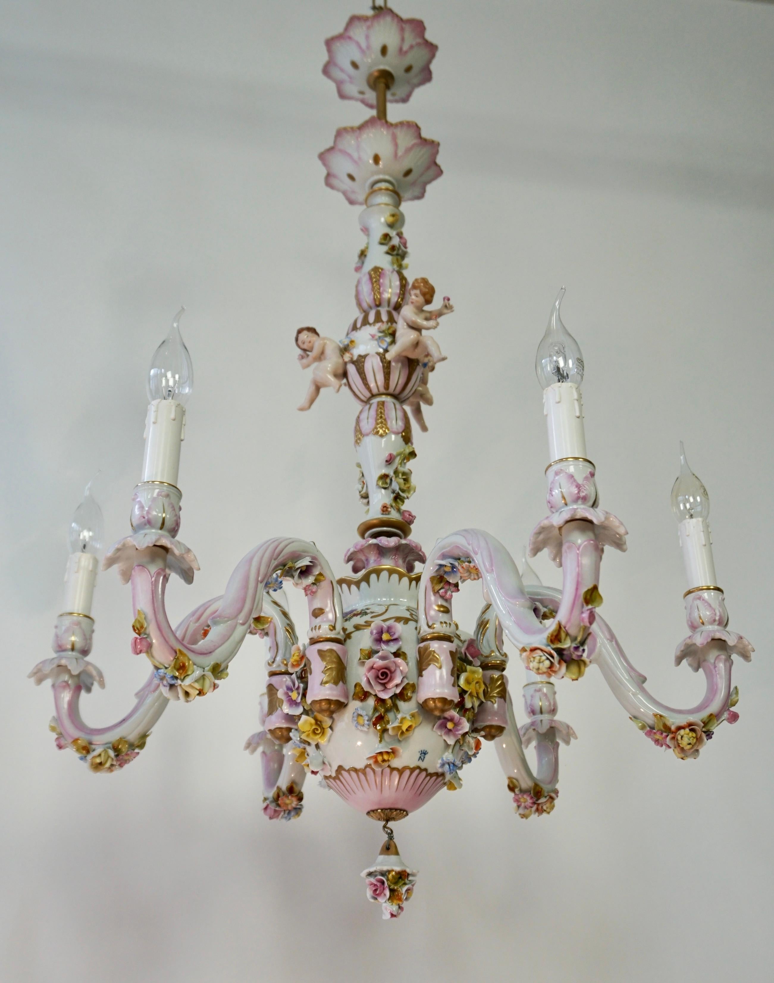 Magnificent Capodimonte chandelier with six lights and three hand painted Cherubs.
This one-tier porcelain chandelier has an exceptional quality. It is crafted and hand painted by the renowned Italian Capodimonte pottery manufacturer. The chandelier