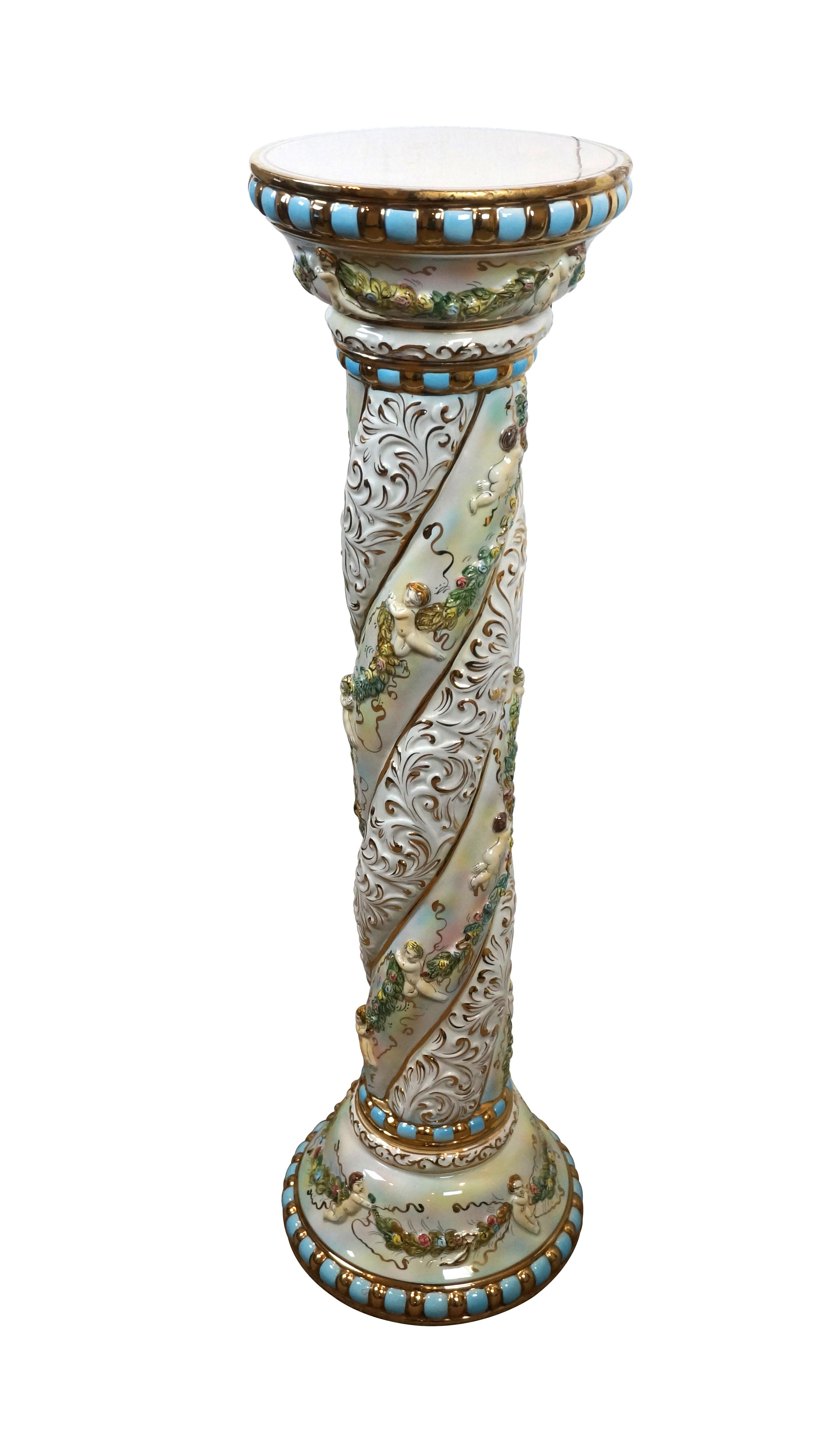 Circa 1950's Italian Capodimonte porcelaine pedestal / column / pillar / planter stand. Colonne torsadée avec base ronde et sommet garni de bleu et d'or et décoré de bandes de guirlandes florales tenues par des chérubins et de bandes de feuillage