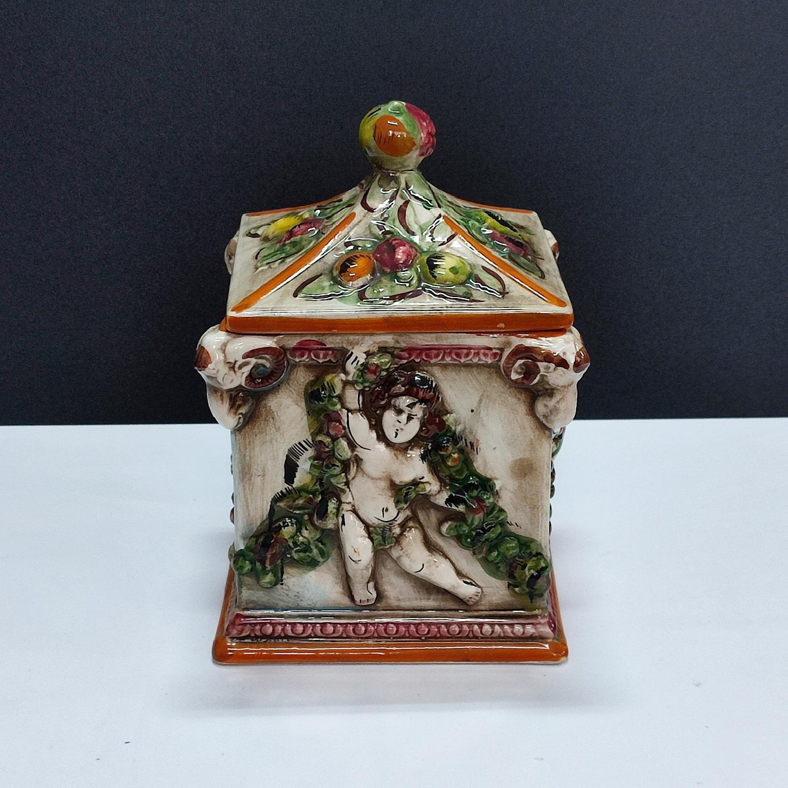Capodimonte Lidded Jar Four Seasons Cherubs Decor. Vintage Italian biscotti jar from the 1950s, handmade and hand-painted. It is a lovely piece that can also be used to decorate your home. Marked Capdimonte on the bottom.
Good overall condition, it