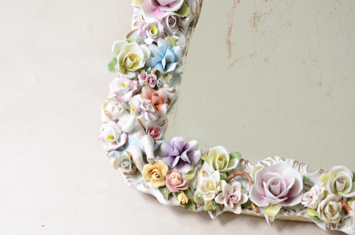 
COD-CV175
Miroir avec un important cadre en porcelaine polychrome avec des décorations de fleurs et d'angelots peintes à la main.

Manufacture de Capodimonte, Naples, 1950 ca.