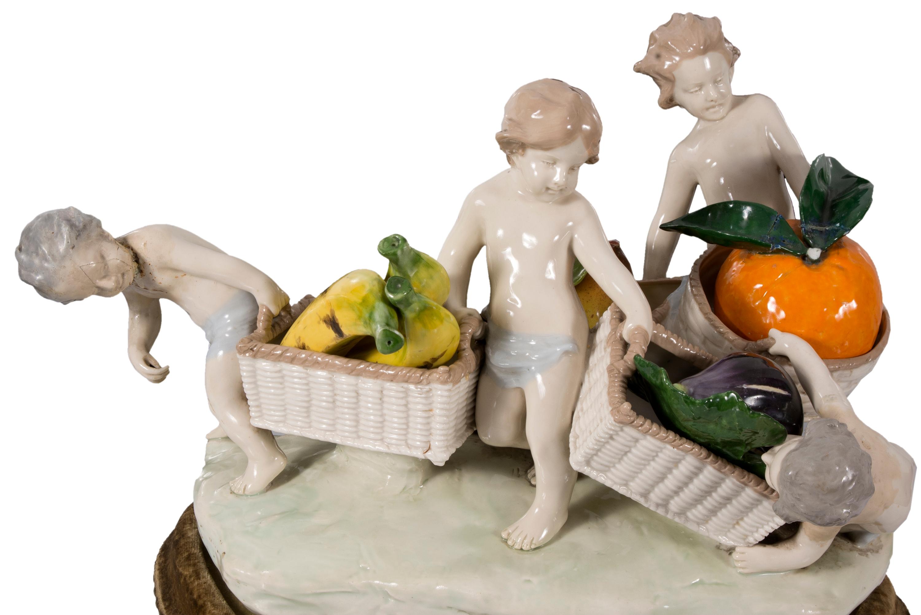 Capodimonte Porzellan Tafelaufsatz, Kinder mit Obstkörben. 20. Jahrhundert.
Größe: 40x30 cm.
Größe und Gewicht sind Orientierungsgrößen.
