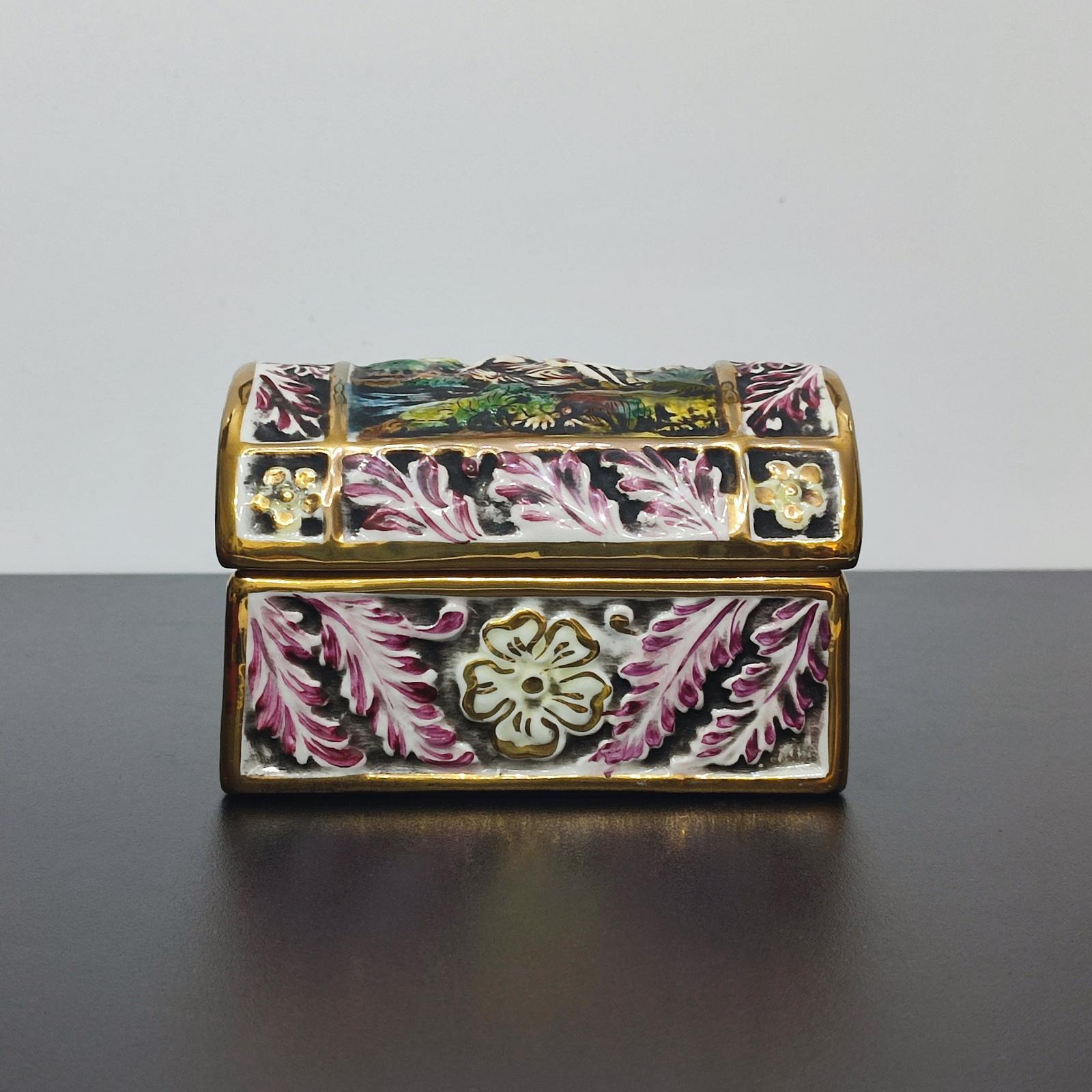 A Mid 20th Century beautiful Capodimonte Porcelain Chest or Jewelry Box
Glazed Porcelain with mark on the base.
Chest with a rectangular base with a domed lid, decorated with a galante scene.
The sides decorated with relief floral designed, enhanced