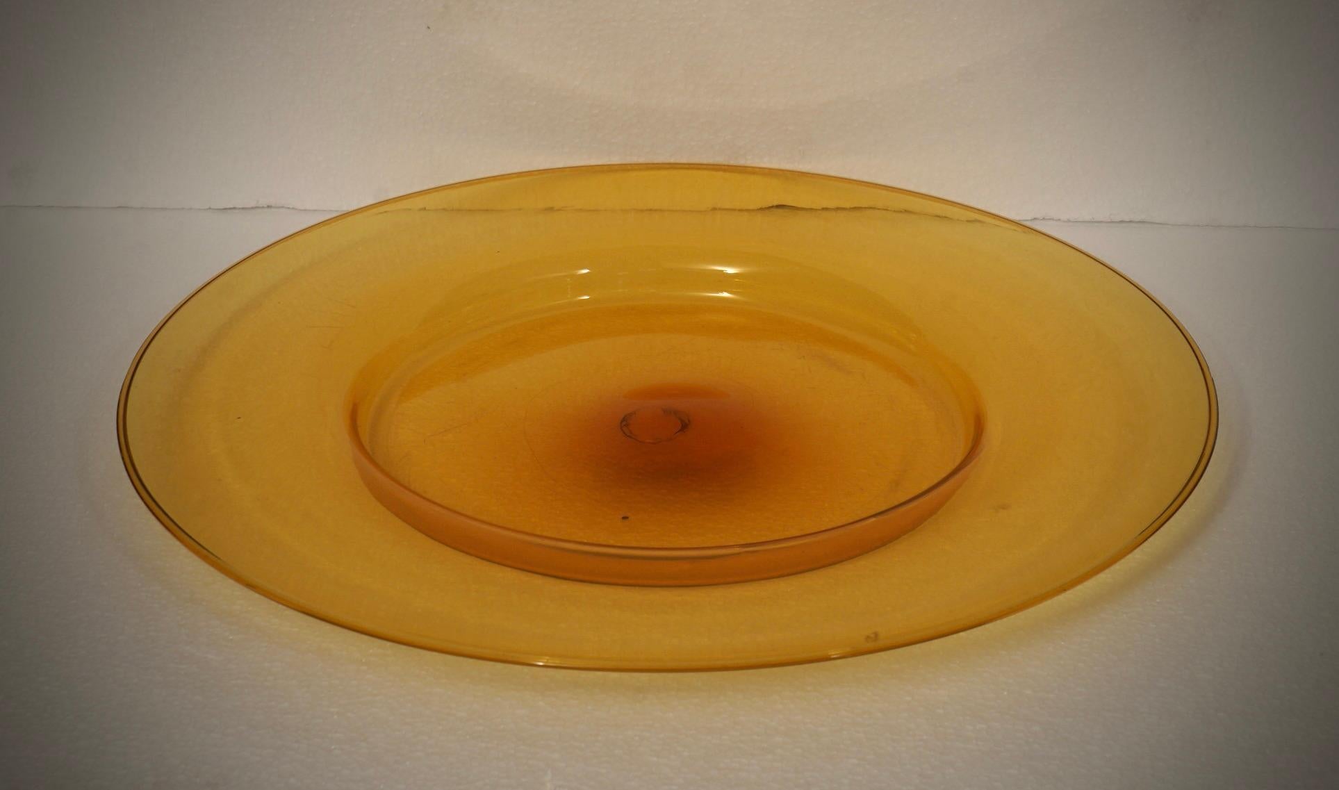 Mit seinen einzigartigen Merkmalen und der Liebe zum Detail ist dieses Stück ein Beweis für die innovative Vision und die künstlerische Sensibilität von Cappellin Murano.

Ein sehr begehrter Teller aus den 1920er Jahren mit orangefarbenem