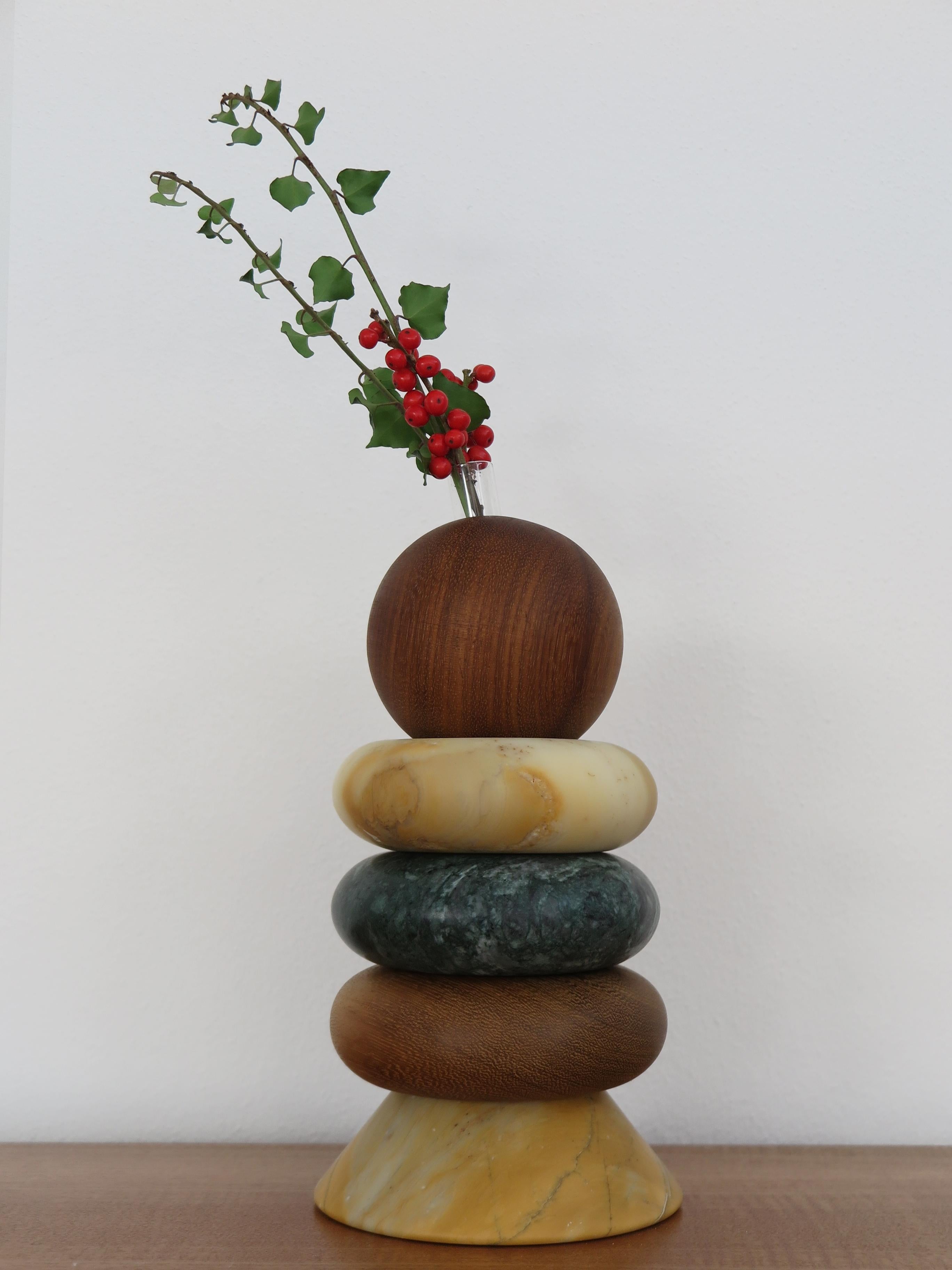 Italian contemporary sculpture, candle holder and flower vase, modular as you like made up of green Alpi marble, yellow Siena marble, and solid wood with including two glass vases for fresh flowers.
The various elements can be composed and stacked