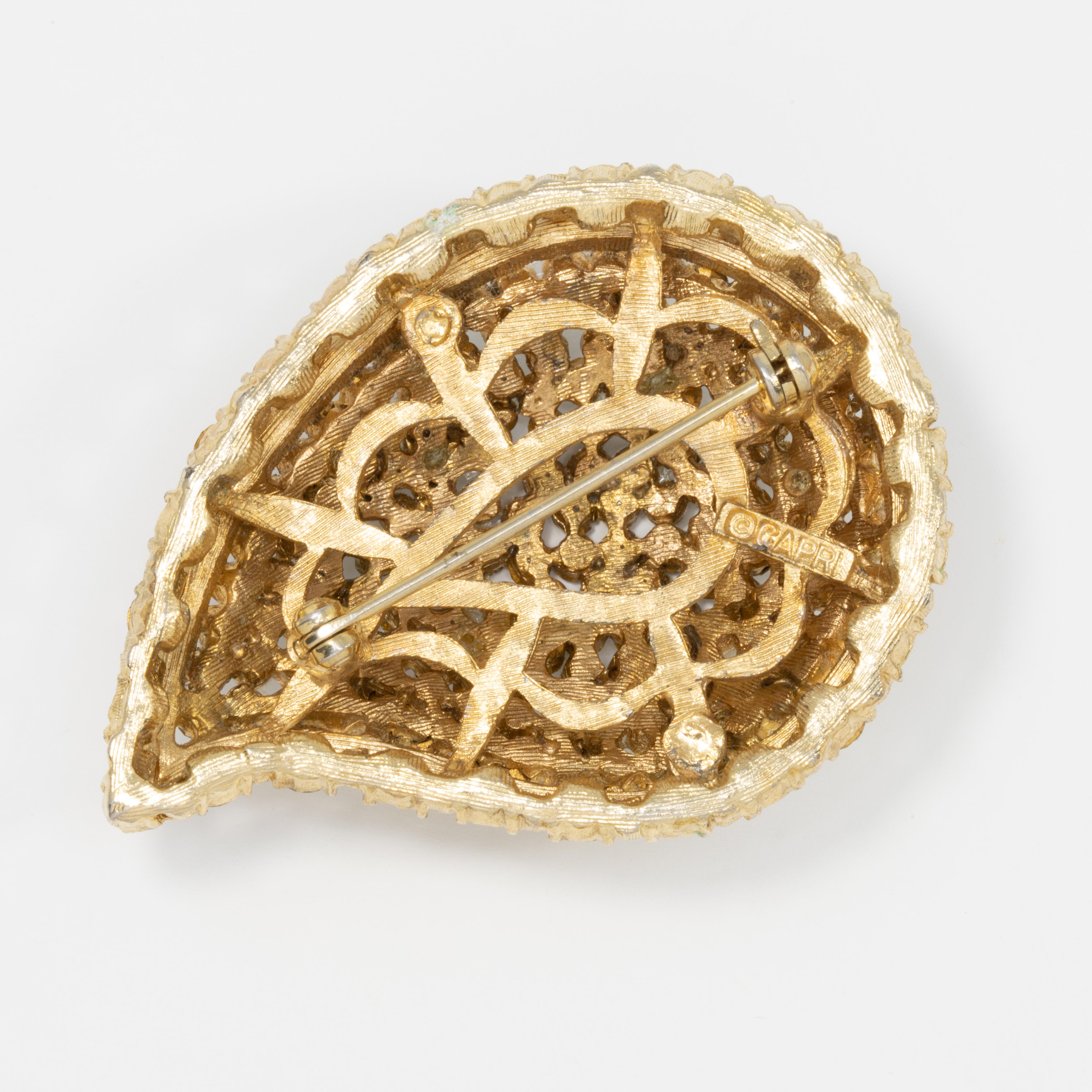 An elegant pin from mid-1900s costume jewelry designer Capri, featuring a gold-tone paisley motif decorated with clear pave crystals. Circa 1960s.

Hallmarks: Capri