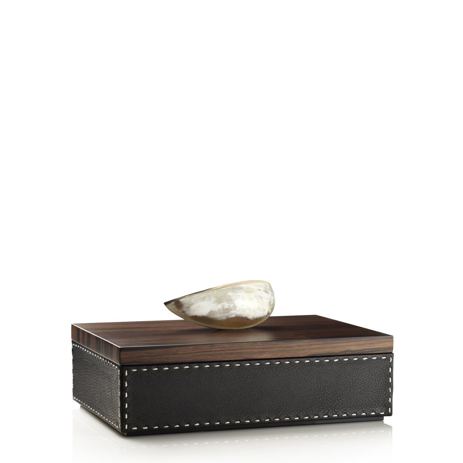 Befitting of all decor, the Capricia rectangular box will be a unique addition to your vanity station or to any other place in your home and office. Clad in Aida pebbled leather in a natural Onyx colour, Capricia sports a cream-colored handmade