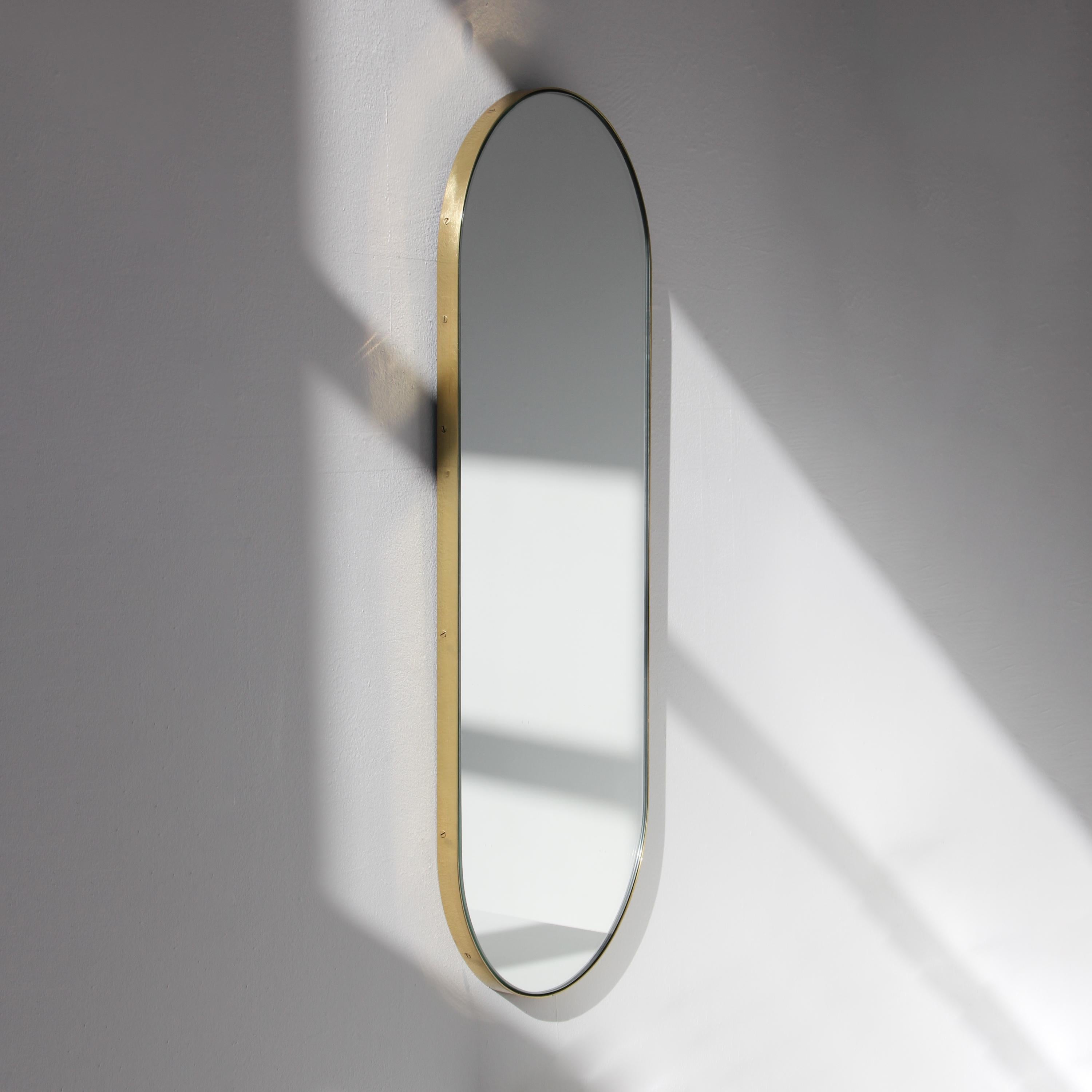 Specchio moderno a forma di pillola Capsula™ con cornice minimalista in ottone massiccio spazzolato. Progettato e realizzato a mano a Londra, nel Regno Unito. Questo specchio è completamente personalizzabile.

I nostri specchi sono stati progettati