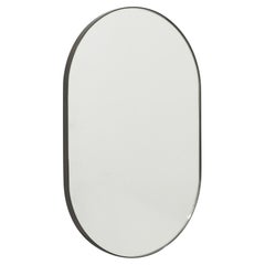 Capsula Miroir moderne en forme de pilule avec cadre en laiton patiné bronze, grand modèle