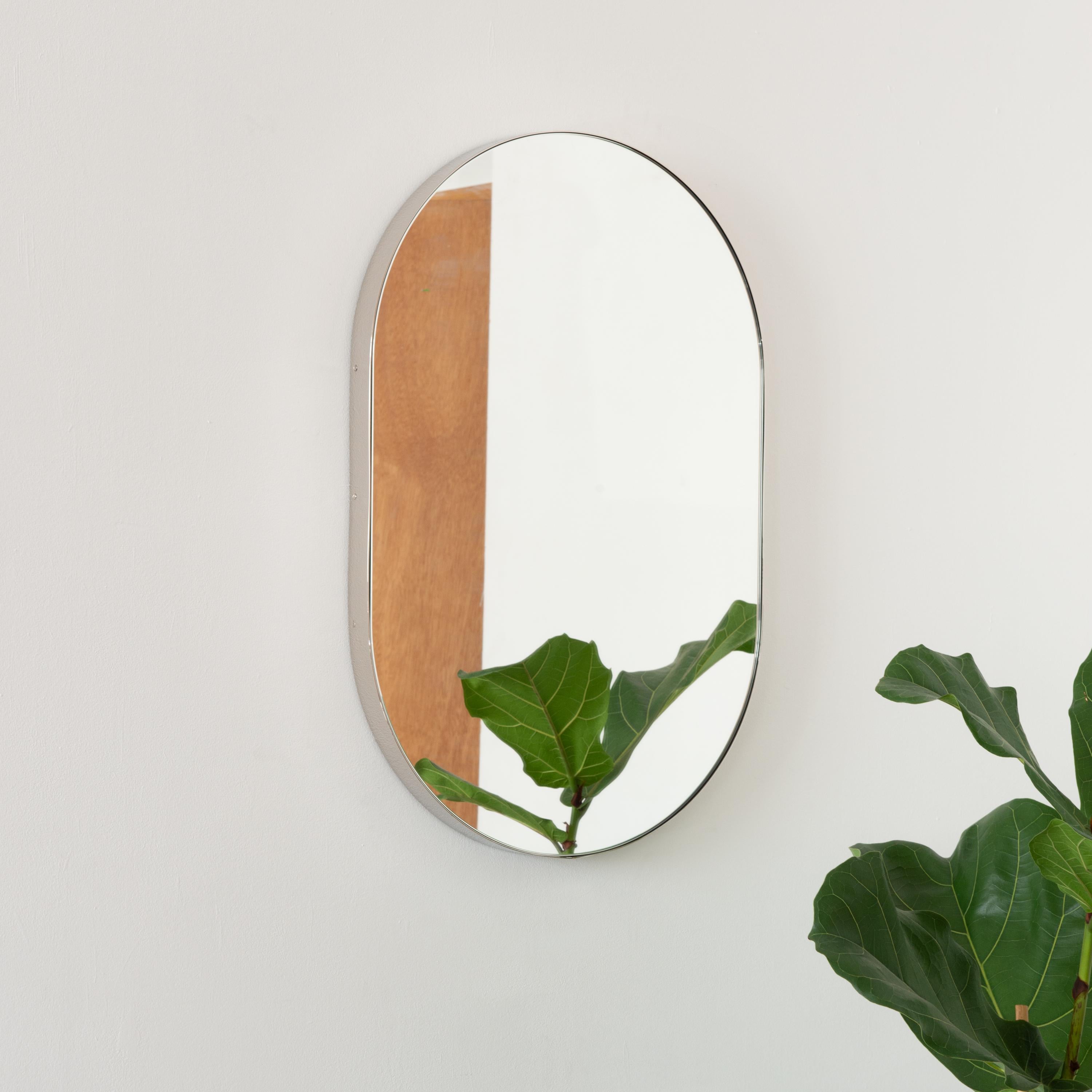 Wunderschöner, kapselförmiger Spiegel mit einem eleganten, vernickelten Rahmen. Entworfen und handgefertigt in London, UK.

Die mittelgroßen, großen und extragroßen Spiegel (37 cm x 56 cm, 46 cm x 71 cm und 48 cm x 97 cm) sind mit einem