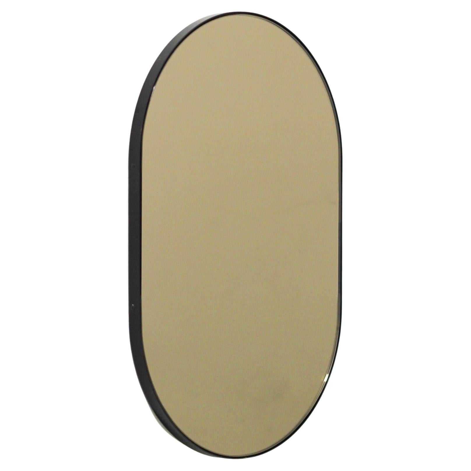 Grand miroir contemporain en forme de capsule en bronze avec cadre noir, Capsula