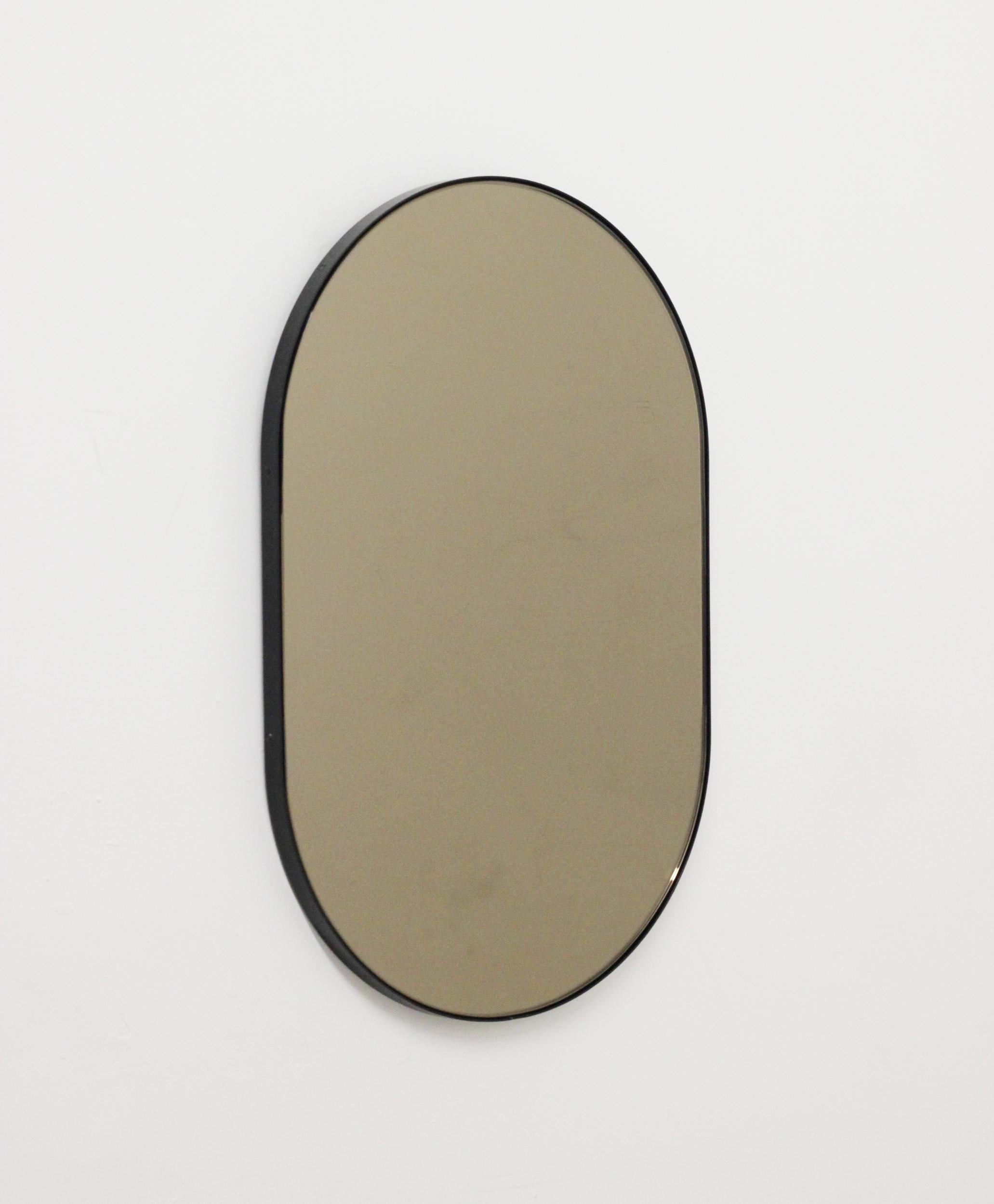 Verniciatura a polvere Specchio contemporaneo Capsula a forma di capsula in bronzo con cornice nera, piccolo in vendita