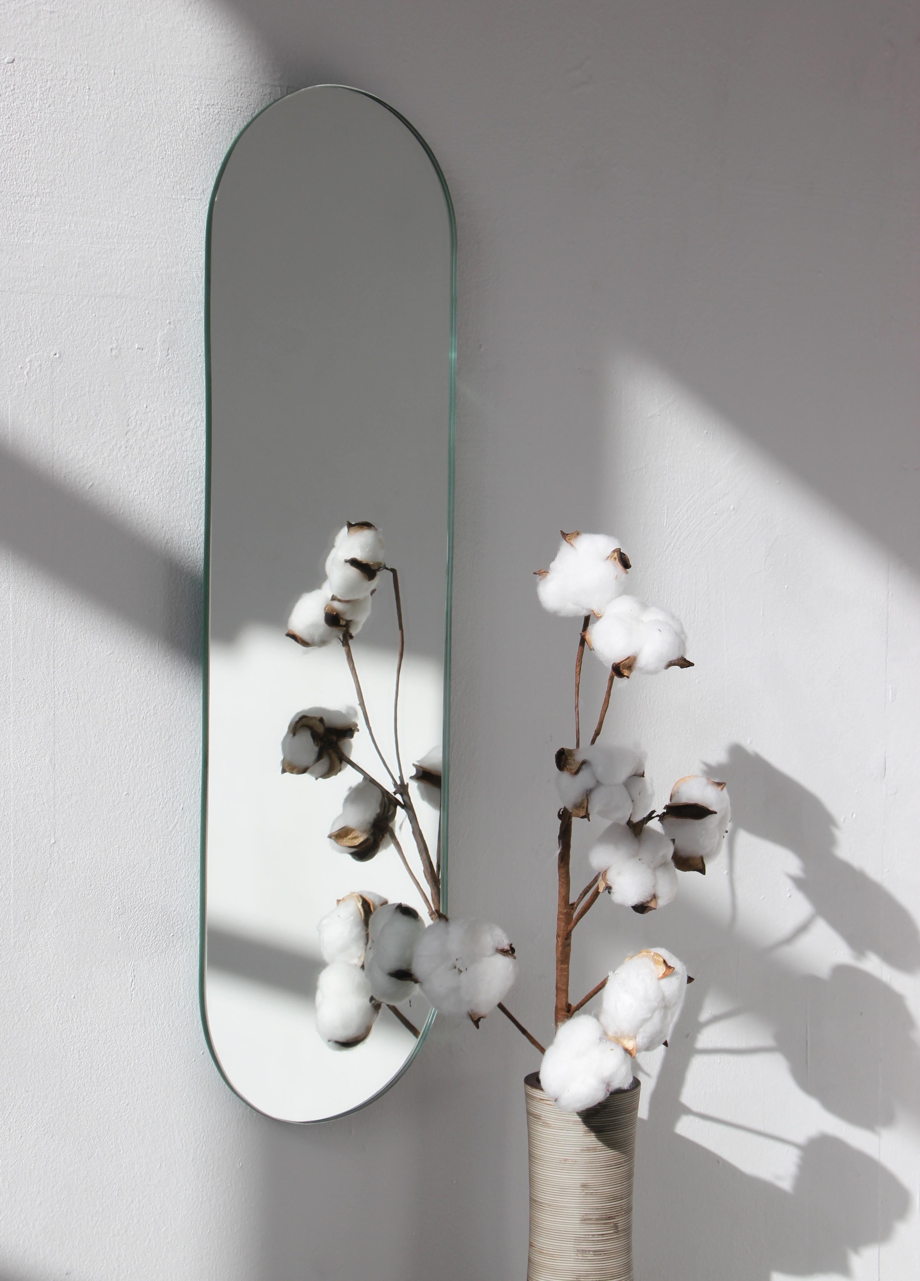 Minimalist Capsula™ capsule / pill shaped frameless mirror. Quality design that ensures the mirror sits perfectly parallel to the wall. Designed and made in London, UK.

Fitted with professional plates not visible once installed for an easy and safe