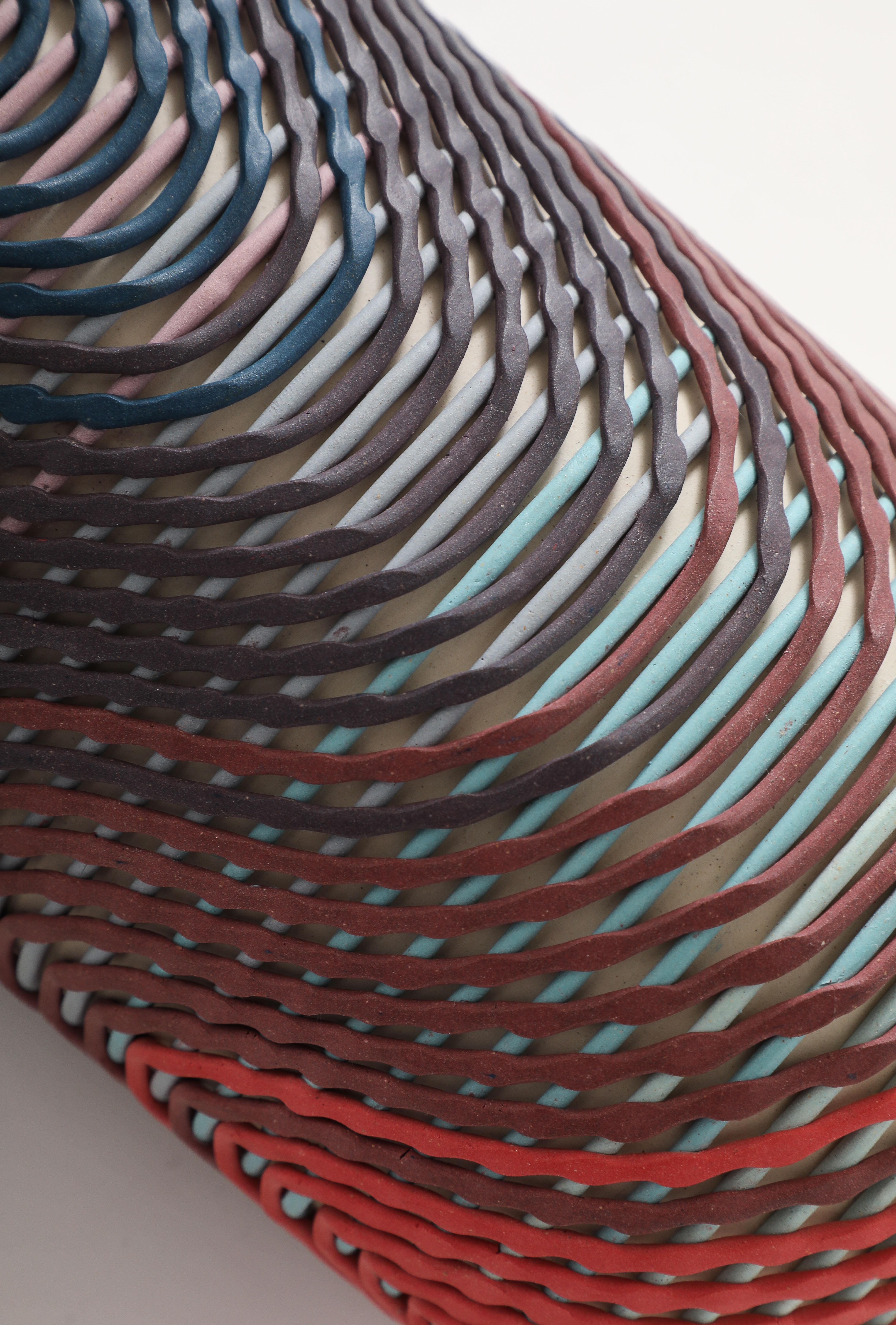 Weißes Steinzeug mit in die Tonmasse eingemischter Malfarbe (Färbemittel).  Spitz zulaufende Füße aus Kupferglanz.

Unterzeichnet