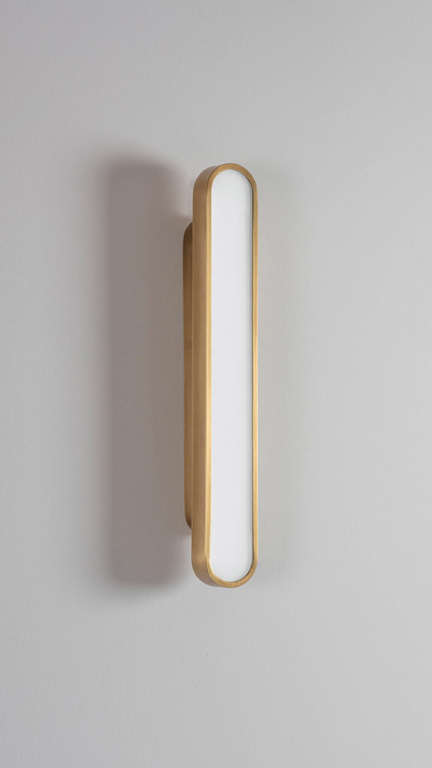 Capsule Golden wall light by Square in Circle
Dimensions: D5 x W5.5 x H40 cm
Materials:Brushed brass/ opaque glass
Other finishes available.

Perfect rounded rectangular shape wall light. Metal wall light is neatly fixed with the same shape